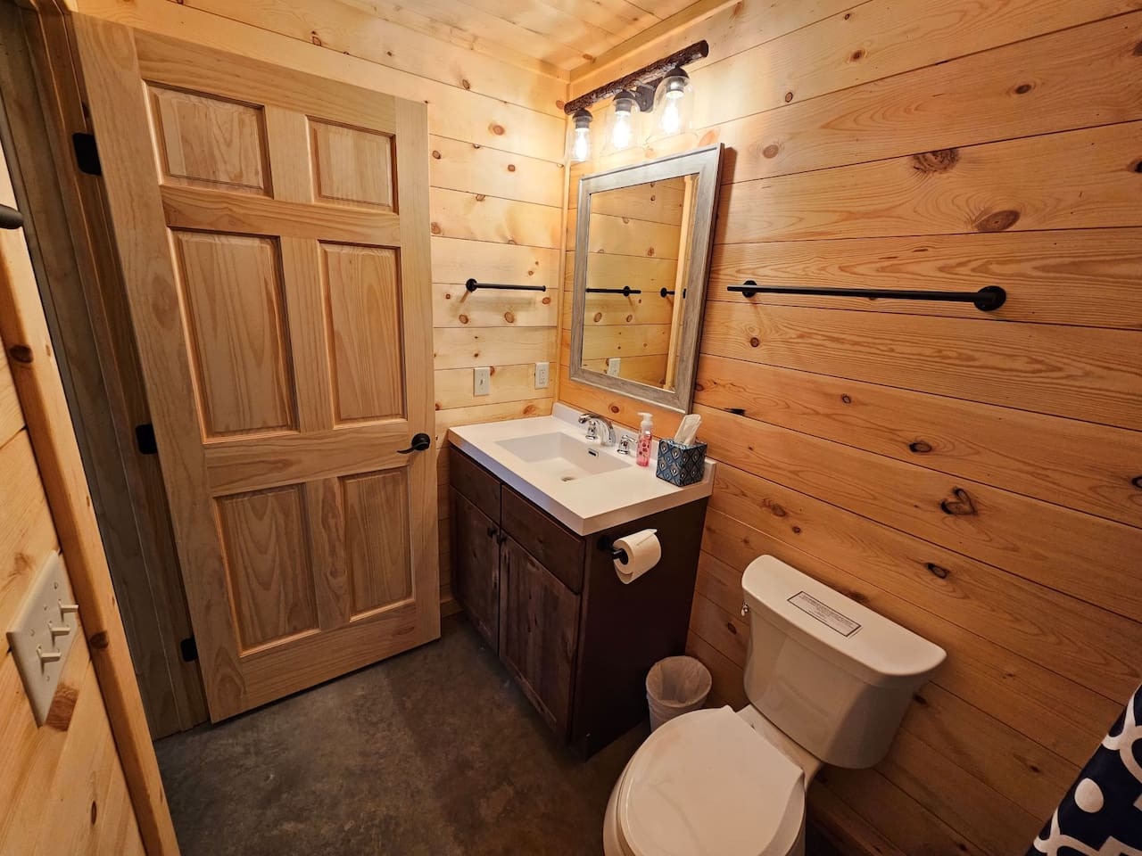 Your rustic bathroom blends warm wood walls with modern amenities, creating a cozy retreat with everything you need.