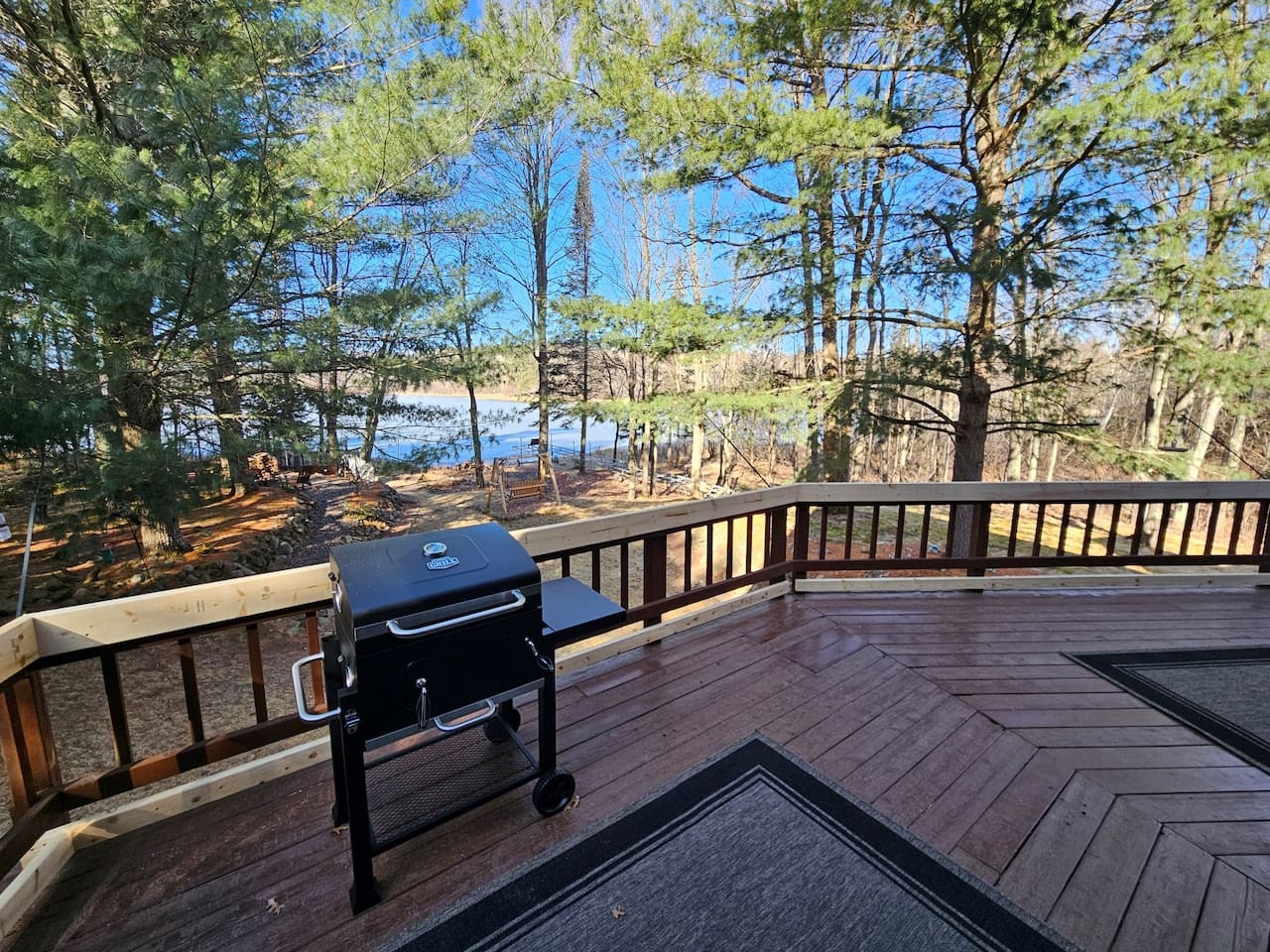 Grill your favorite meals on this spacious deck while enjoying stunning lake views through the trees.