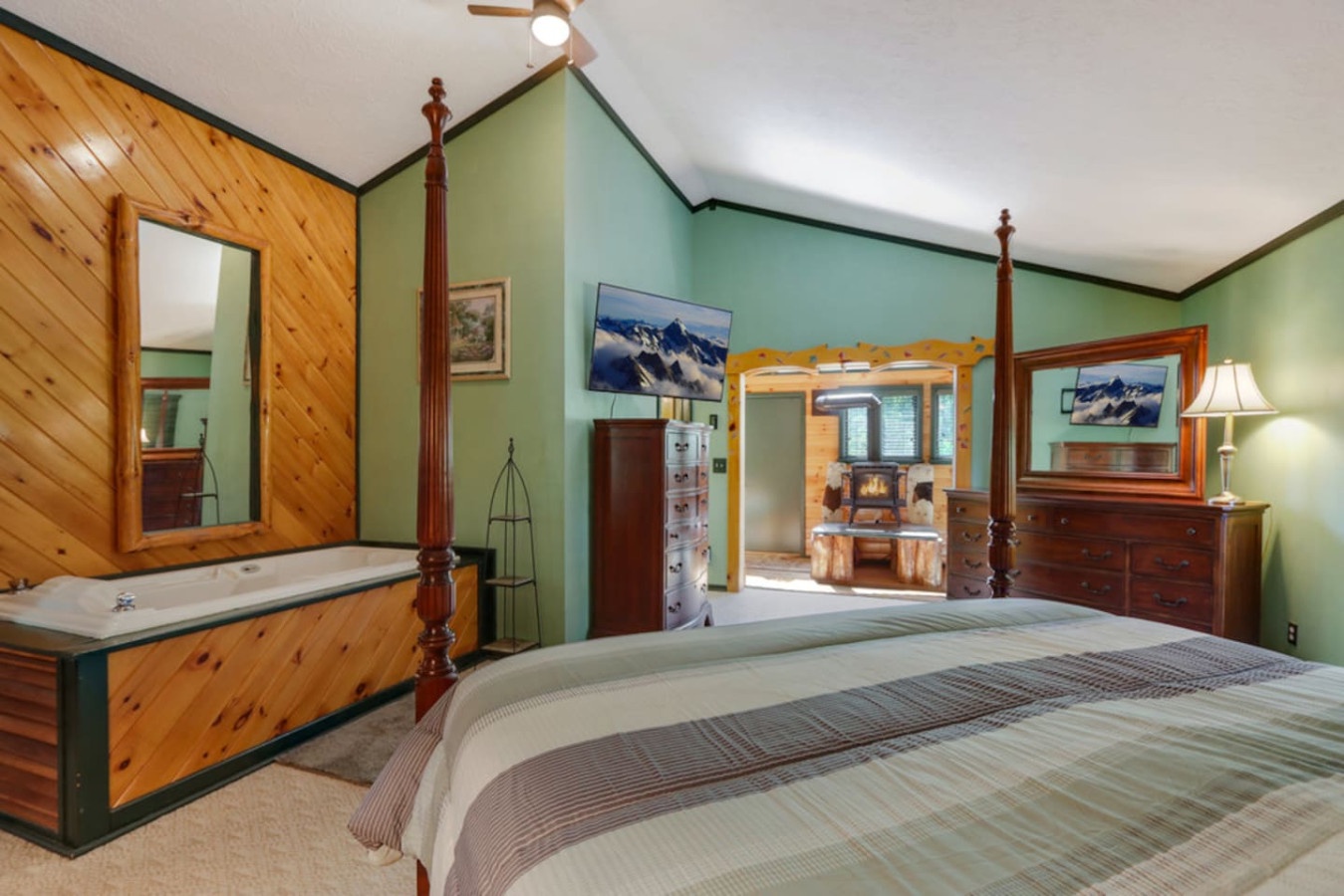 Rest in your rustic mountain retreat featuring a luxurious jetted tub, warm wood accents, and cozy four-poster bed perfect for romantic getaways.