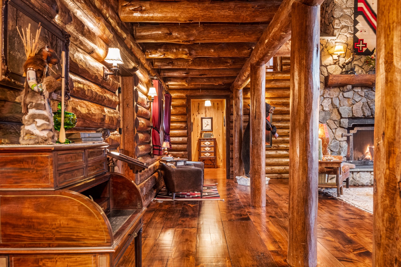 Step into rustic luxury with handcrafted log walls, gleaming hardwood floors, and a cozy stone fireplace that creates your perfect mountain retreat.