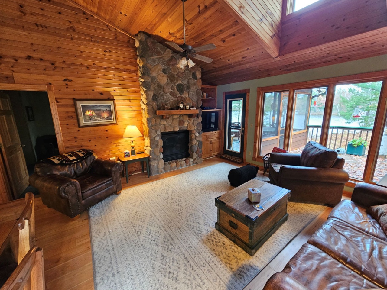 Sink into plush leather seating by your crackling stone fireplace, where rustic wood beams and warm lighting create the perfect mountain retreat atmosphere.