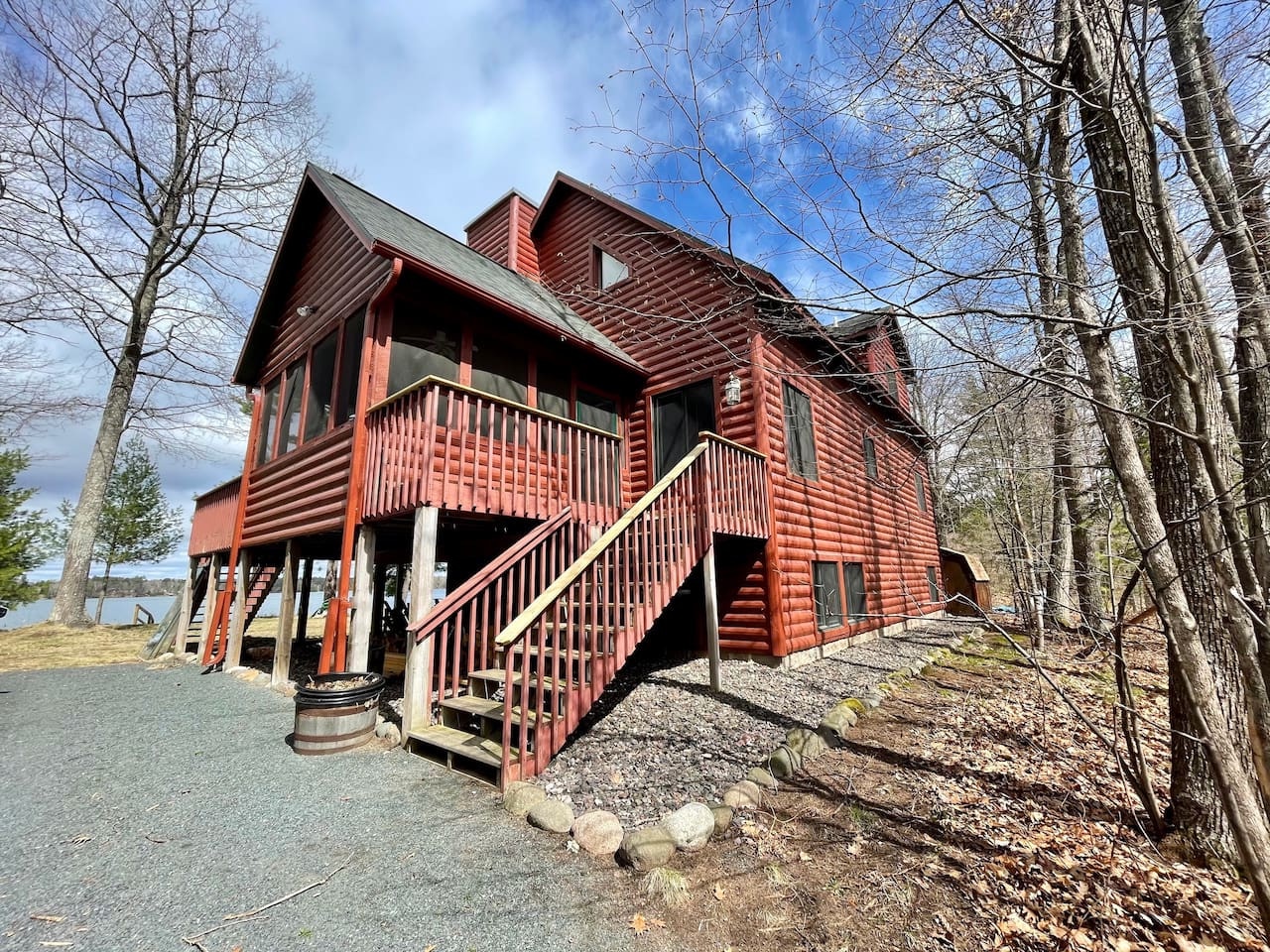 Rustic red cedar cabin nestled among towering trees, offering a perfect woodland retreat with lake access nearby.