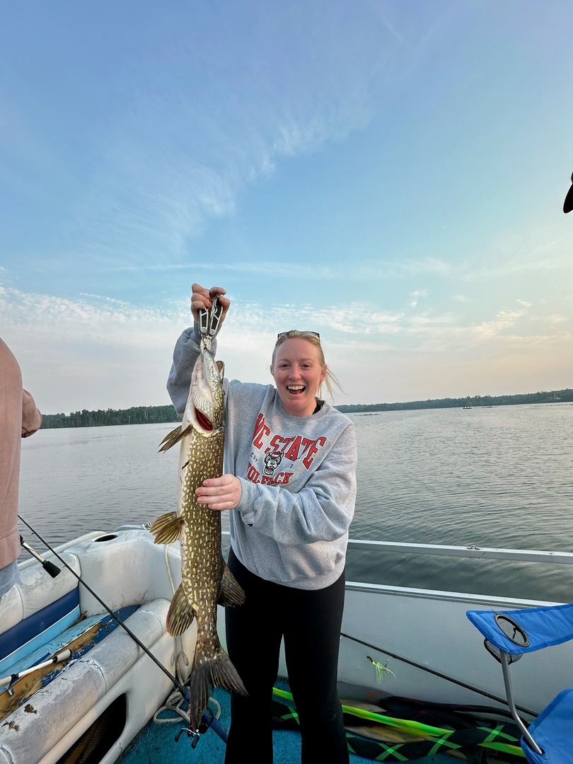A serene lake offers prime fishing opportunities, framed by forested shores and peaceful waters—ideal for outdoor adventure seekers.