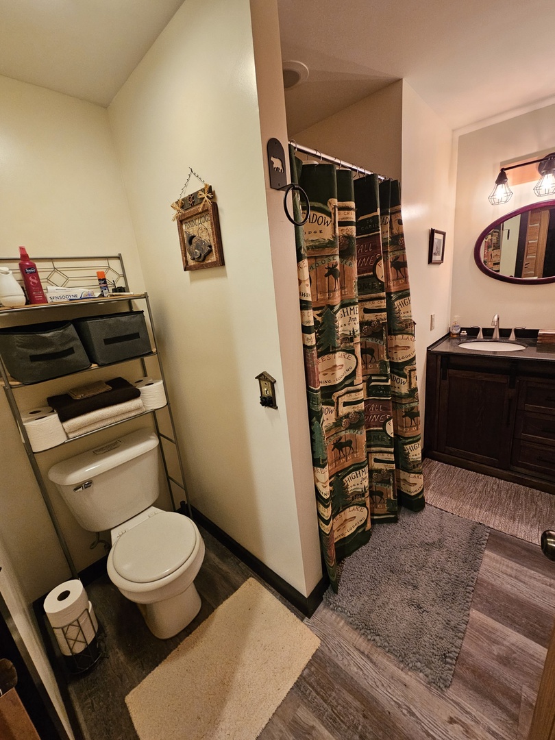 Your private bathroom features rustic charm with wilderness-themed décor, modern vanity, and all the essentials for a comfortable stay.