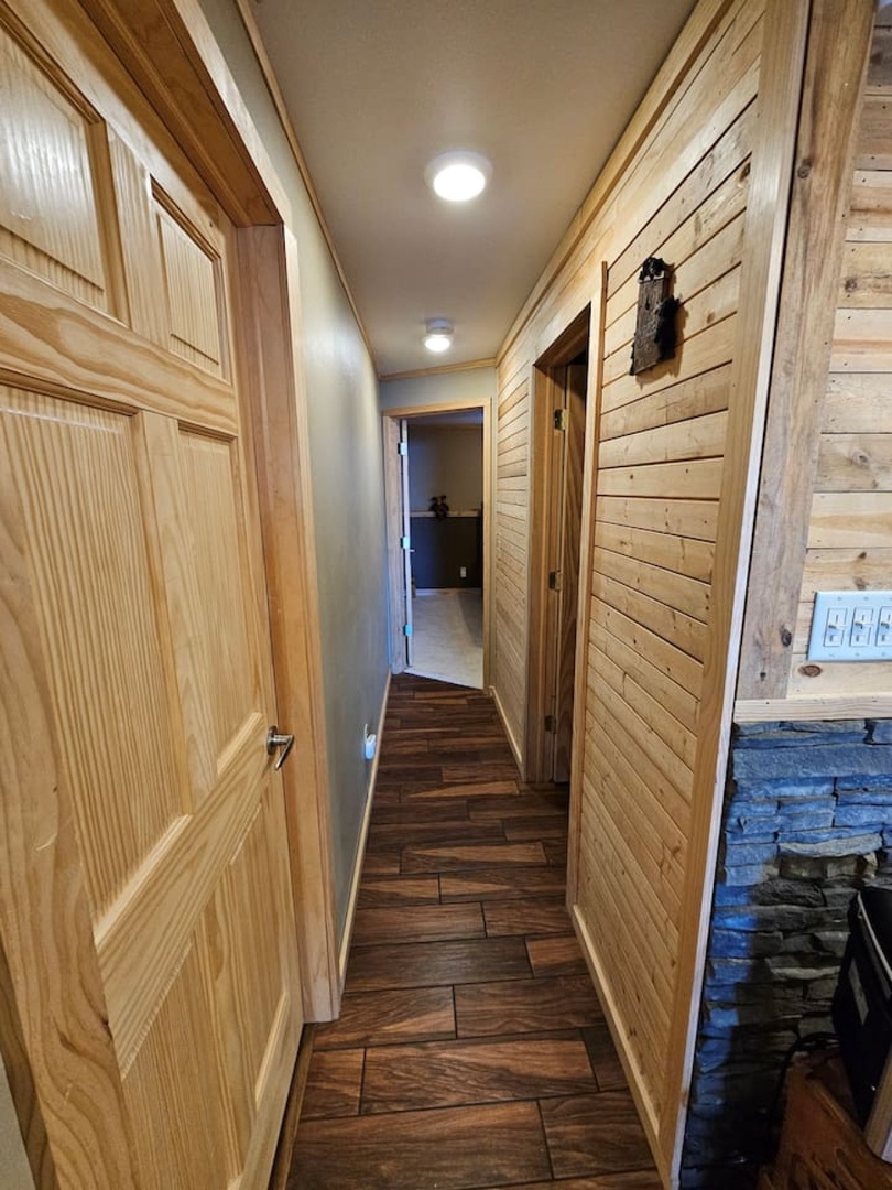 Step into your rustic retreat's warm hallway, where rich wood walls and gleaming floors create a cozy mountain cabin feel.