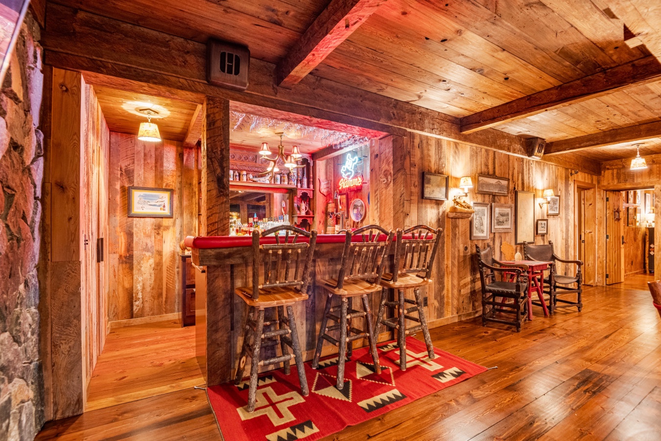 Step into your rustic retreat's cozy bar area where warm wood beams and vintage charm create the perfect spot for evening conversations.