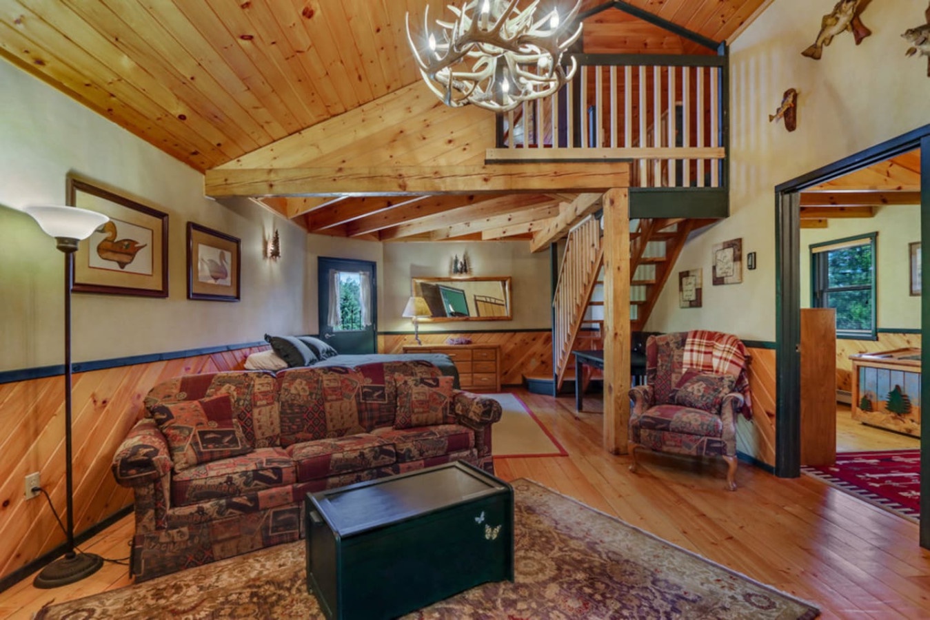 Cozy up in your rustic retreat with exposed beams, plaid furnishings, and warm wood accents creating the perfect mountain lodge atmosphere.