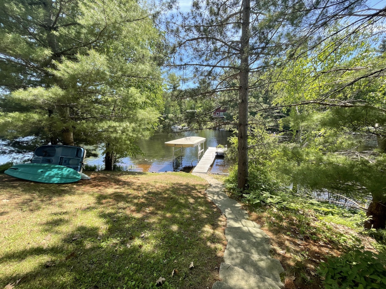 Peaceful lakefront setting with private dock and boat access surrounded by mature trees and natural beauty.