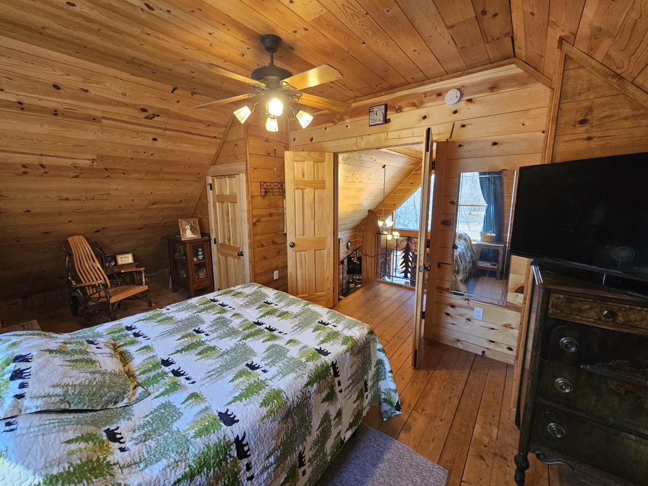 Step into your cozy log cabin bedroom where rustic wood surrounds you in warmth and comfort, complete with modern amenities.