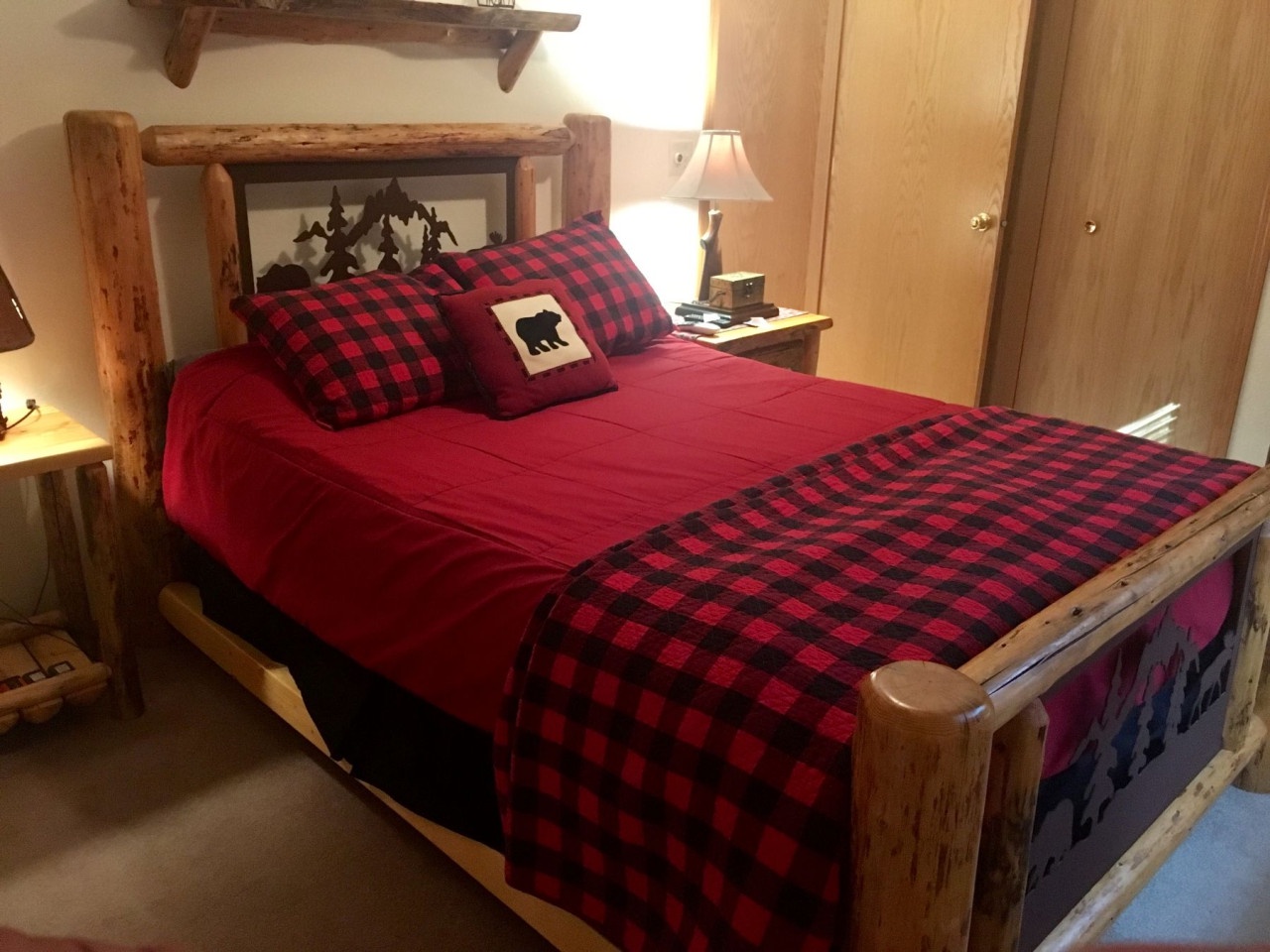 Cozy up in your rustic log bed with plaid linens and woodland charm for a perfect mountain retreat experience.