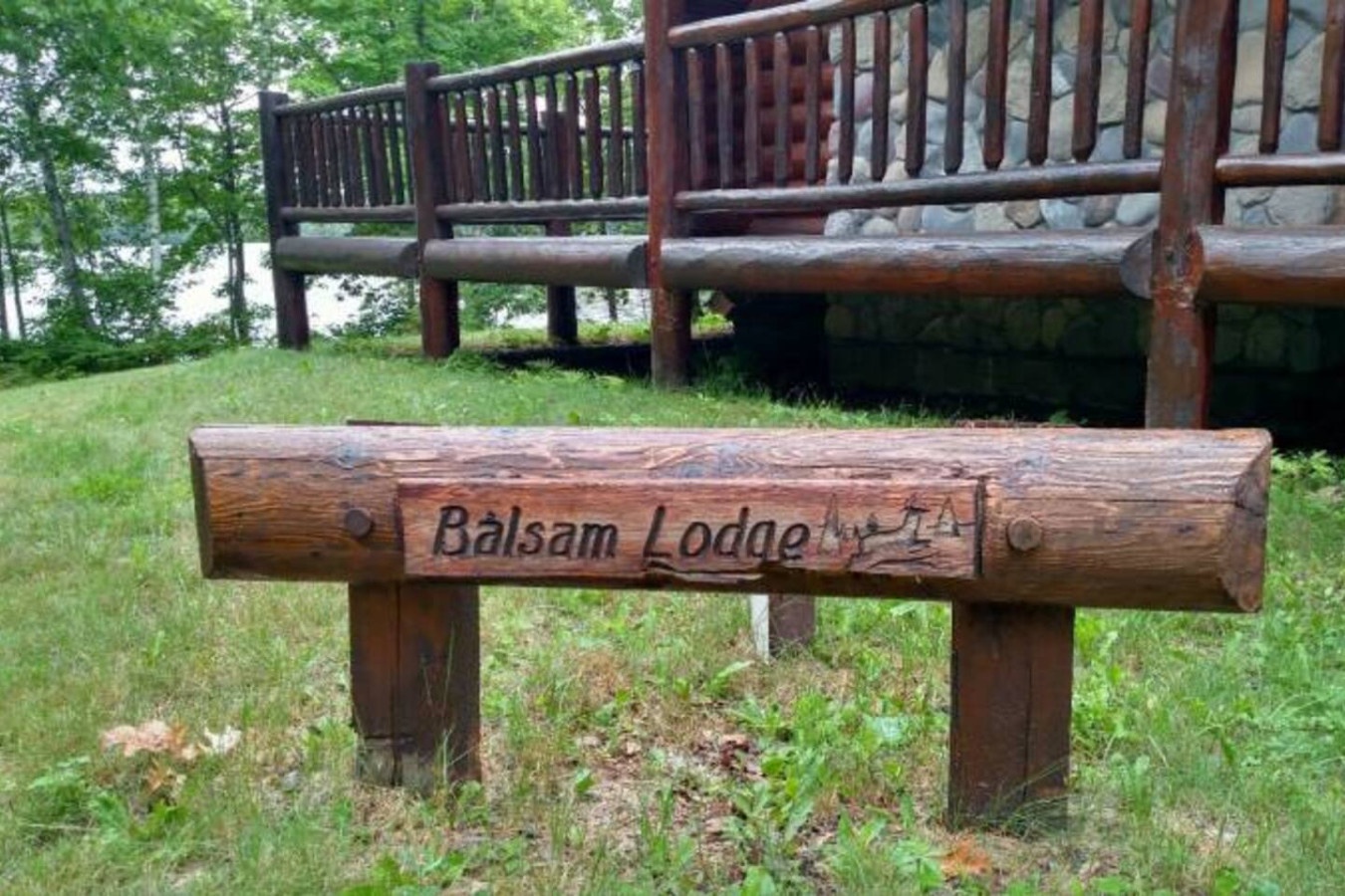 Welcome to Balsam Lodge, where rustic wooden signage marks your arrival at this peaceful retreat surrounded by lush forest.