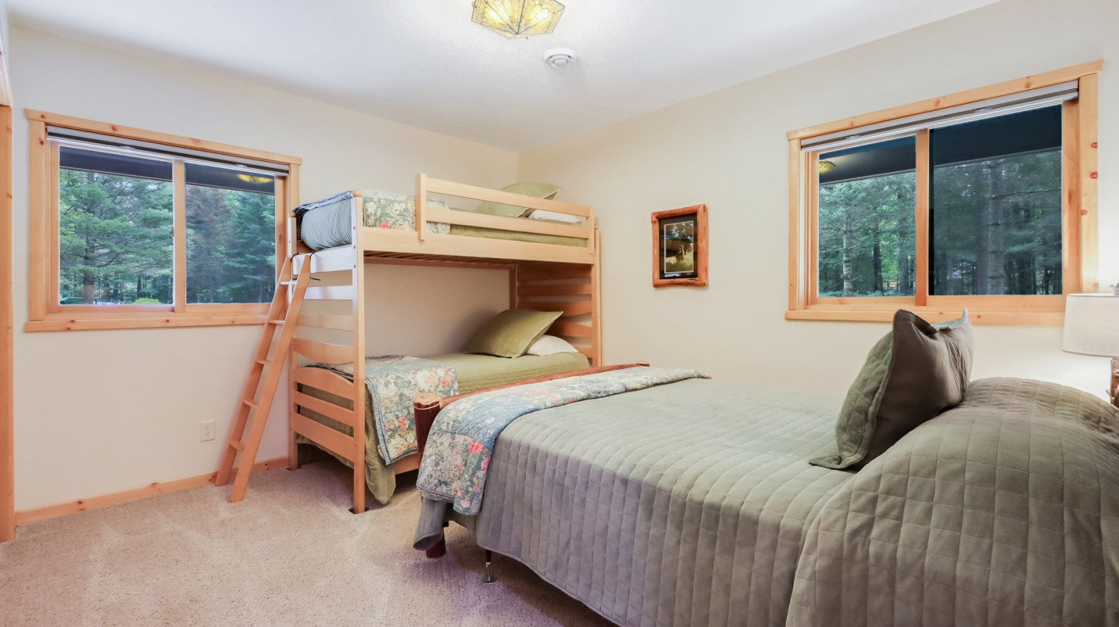 Rest peacefully in your cozy bedroom with forest views and comfortable sleeping arrangements for the whole family.