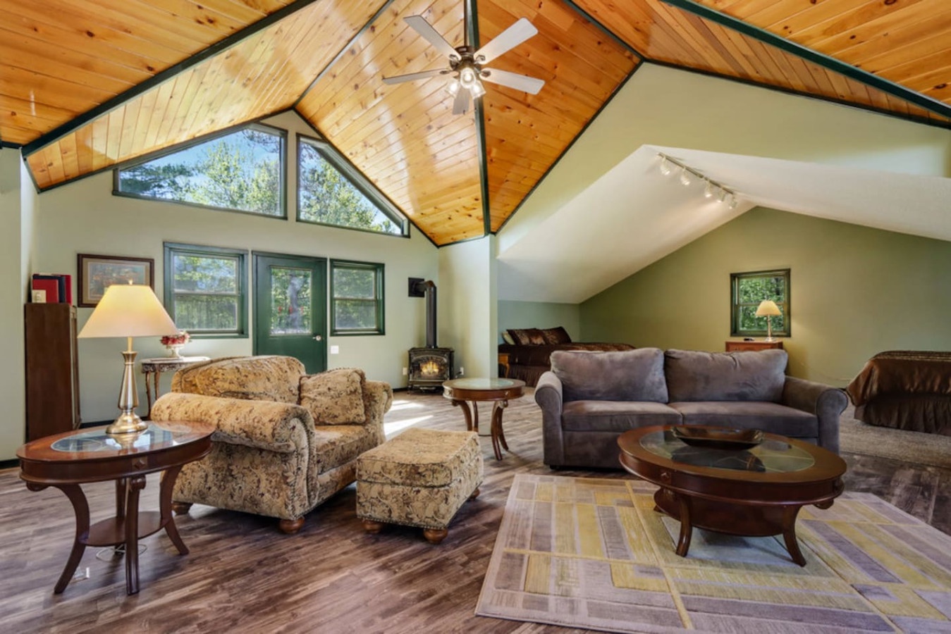 Unwind in your spacious living room with vaulted ceilings, cozy fireplace, and abundant natural light streaming through panoramic windows.