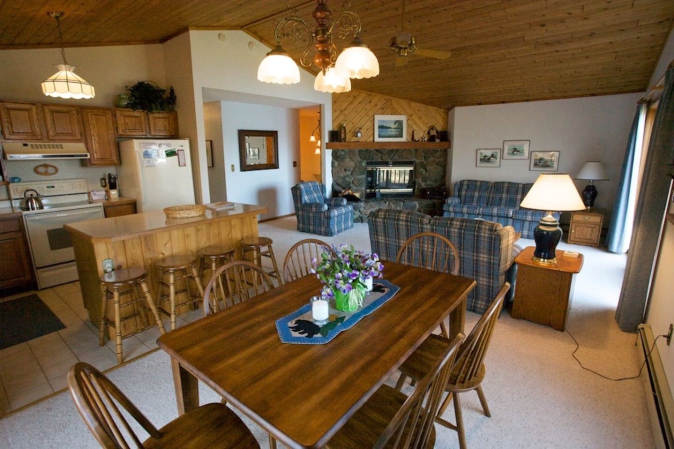 Relax in this cozy mountain-style home featuring warm wood accents, a stone fireplace, and an open layout perfect for family gatherings.