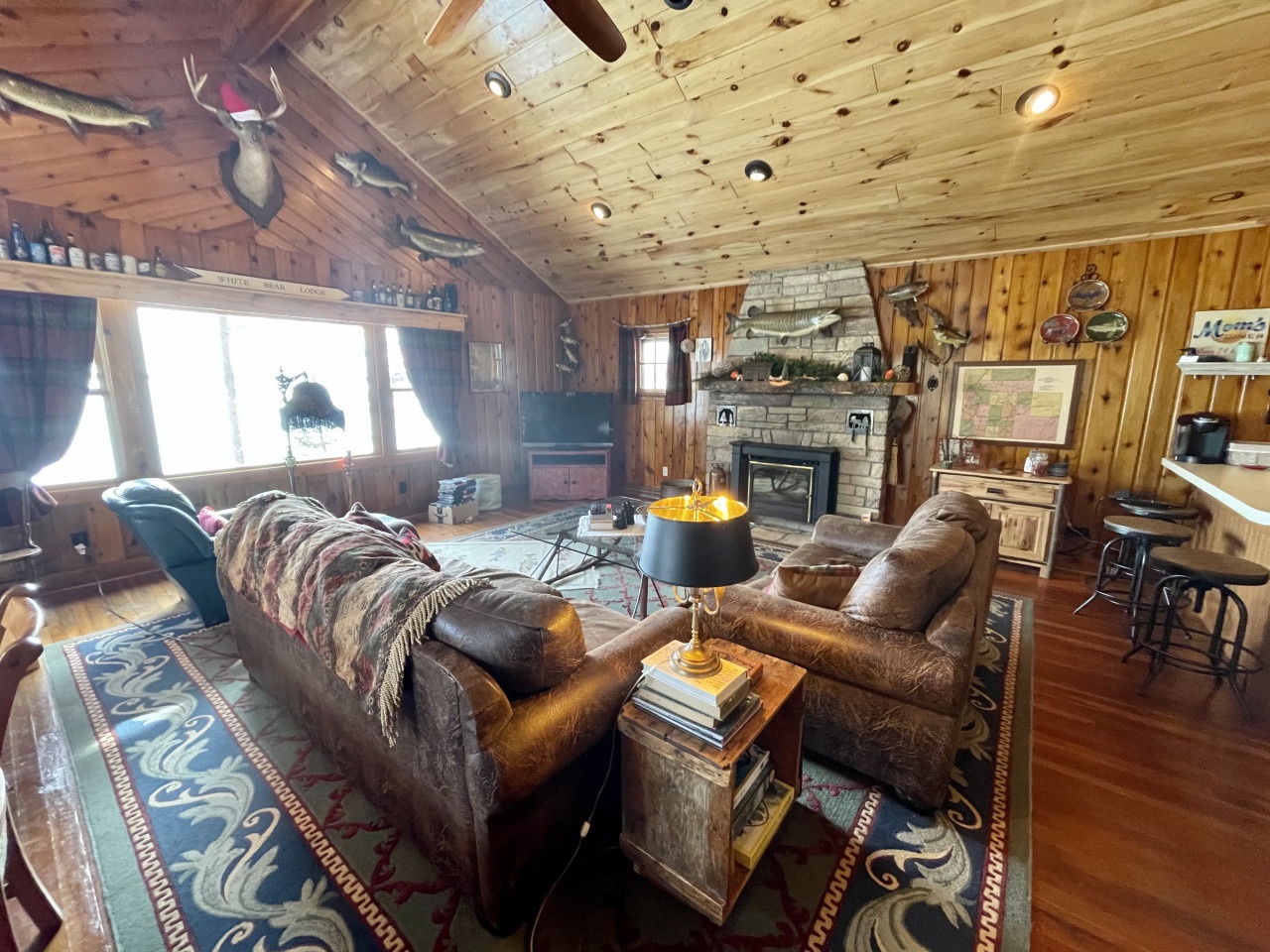 Sink into leather sofas by the stone fireplace in this rustic cabin, where hunting trophies and fishing lore create your perfect wilderness retreat.