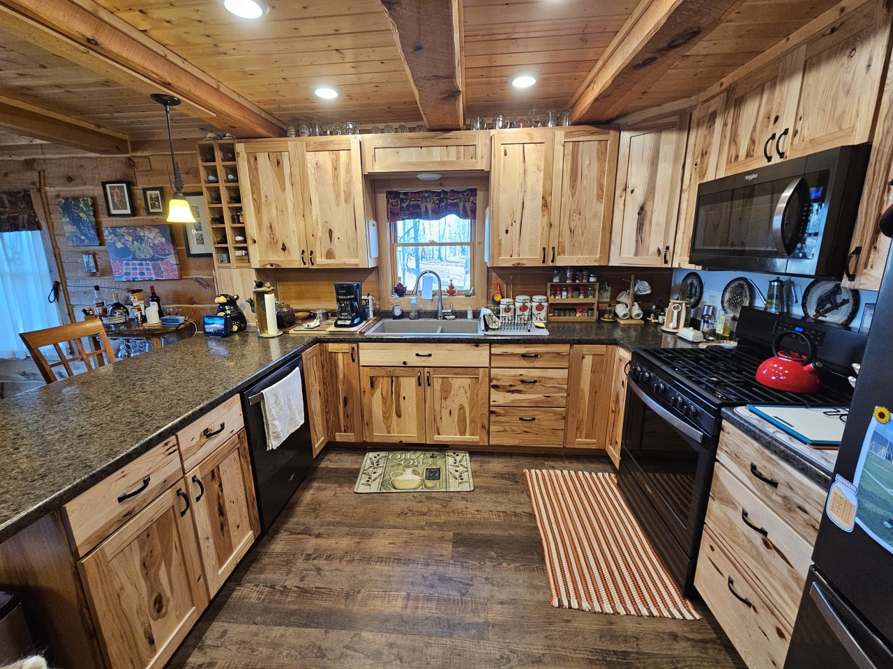 Your fully-equipped rustic kitchen invites culinary adventures with natural wood cabinets, granite counters, and modern appliances for memorable meal preparation.