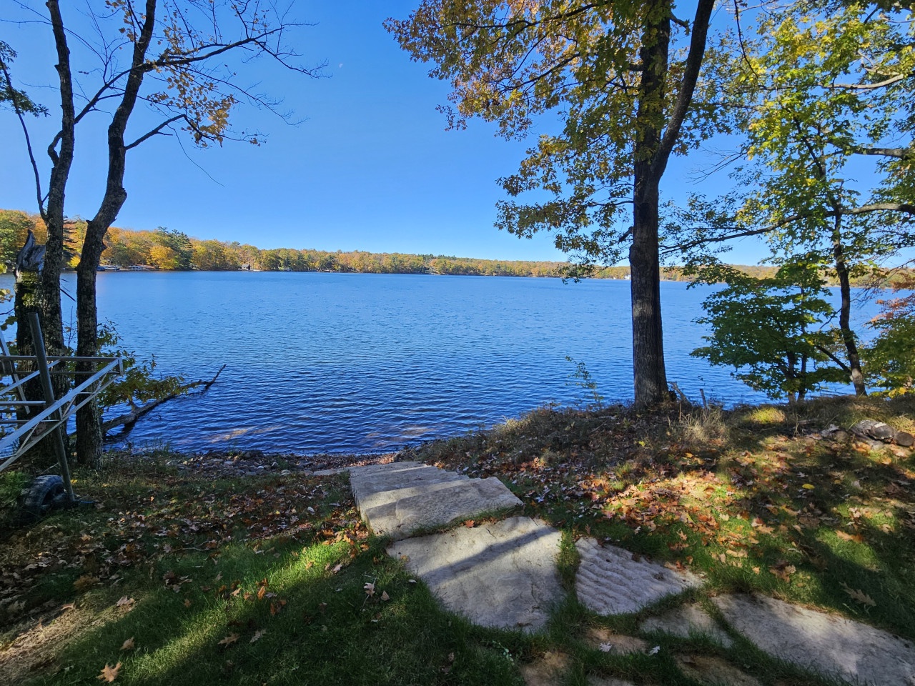 Stunning lakefront property with pristine waters, autumn foliage, and private shoreline access creating the perfect seasonal retreat.
