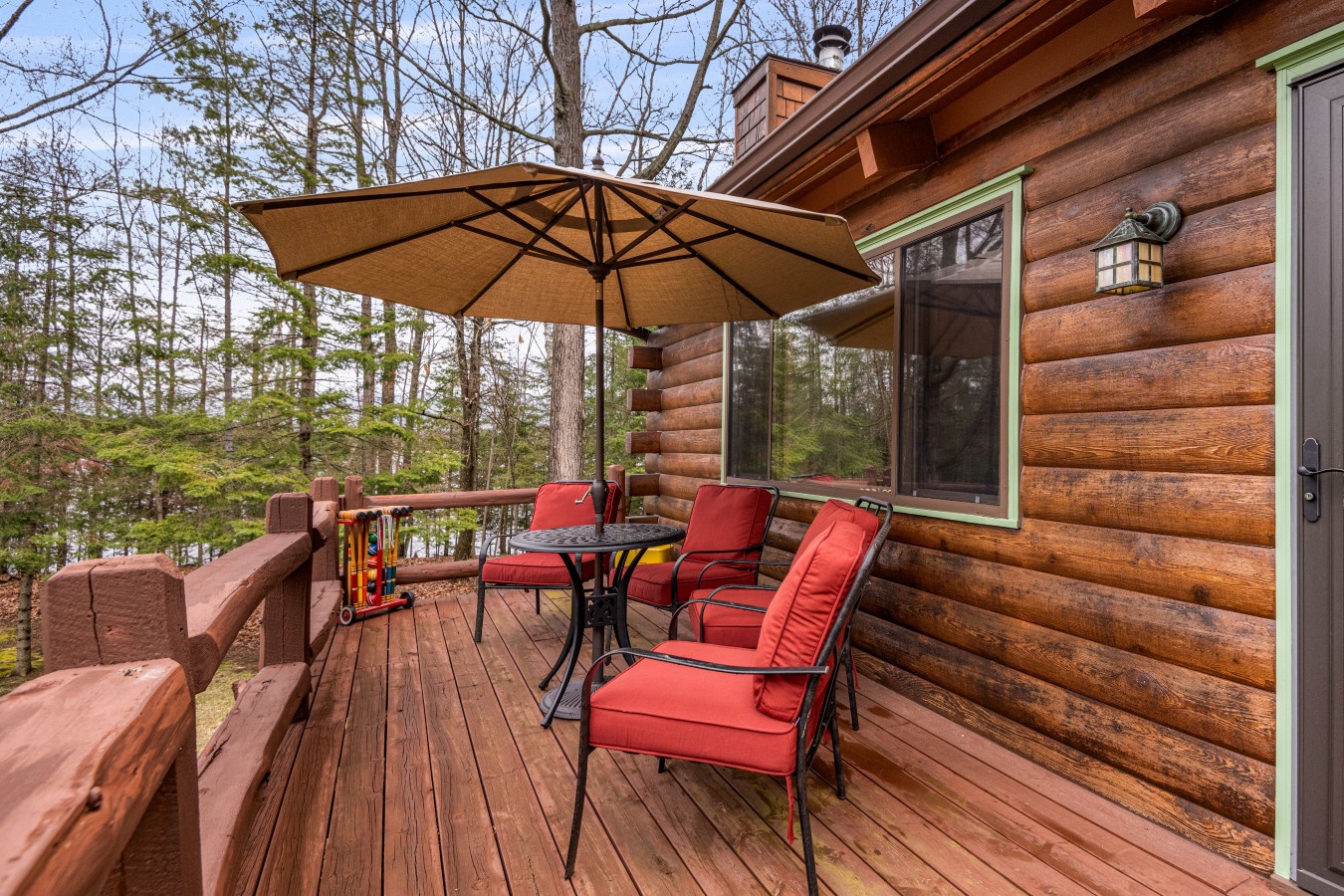 Relax on your private deck with comfortable seating and umbrella shade, surrounded by peaceful forest views.