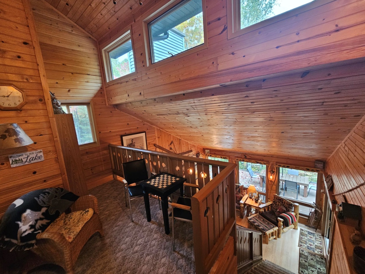 Step into your cozy cabin loft where rich wood surrounds you and natural light streams through skylights, creating perfect reading nooks.