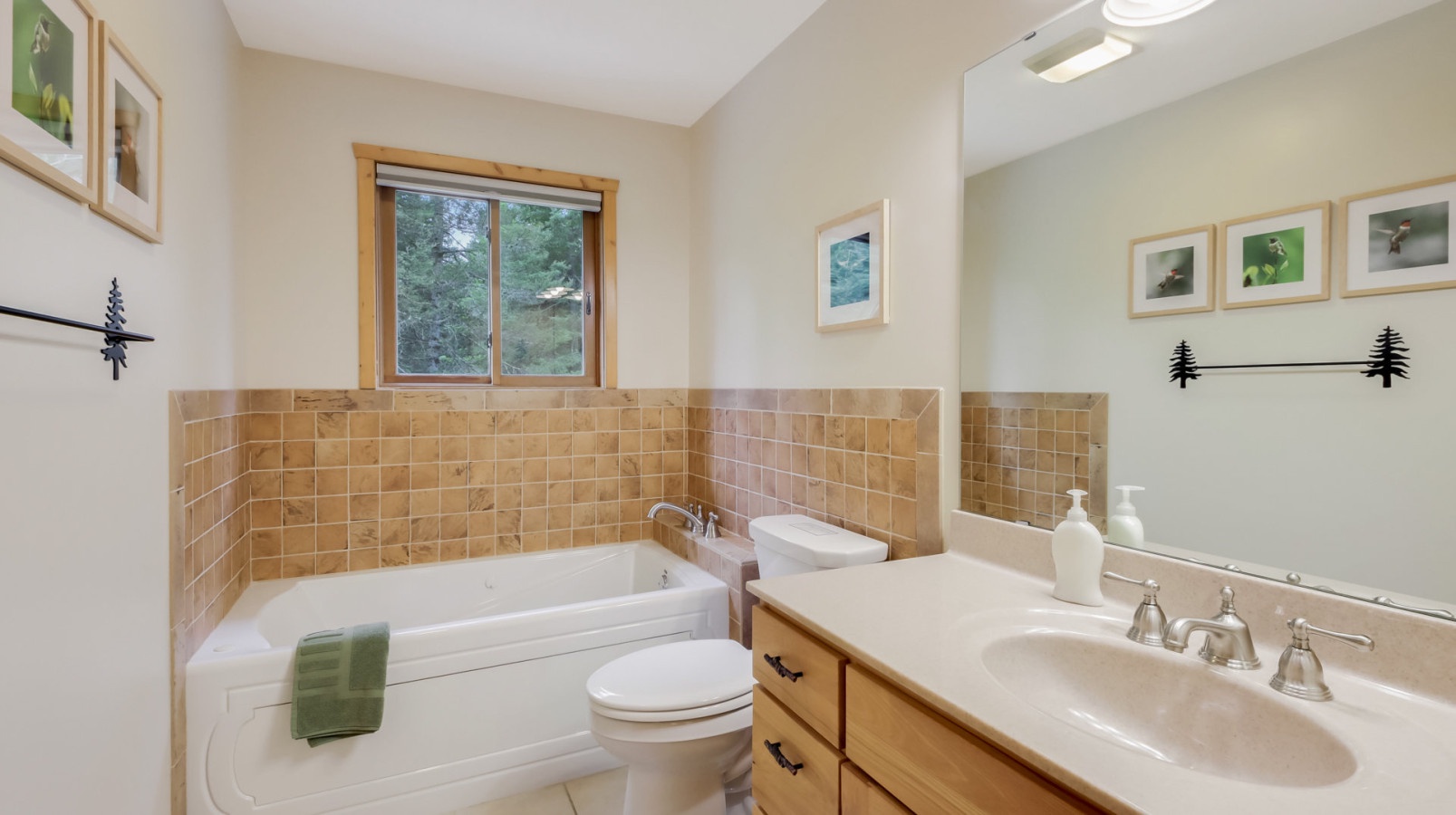 Unwind in your private bathroom featuring a deep soaking tub and nature views through the window.