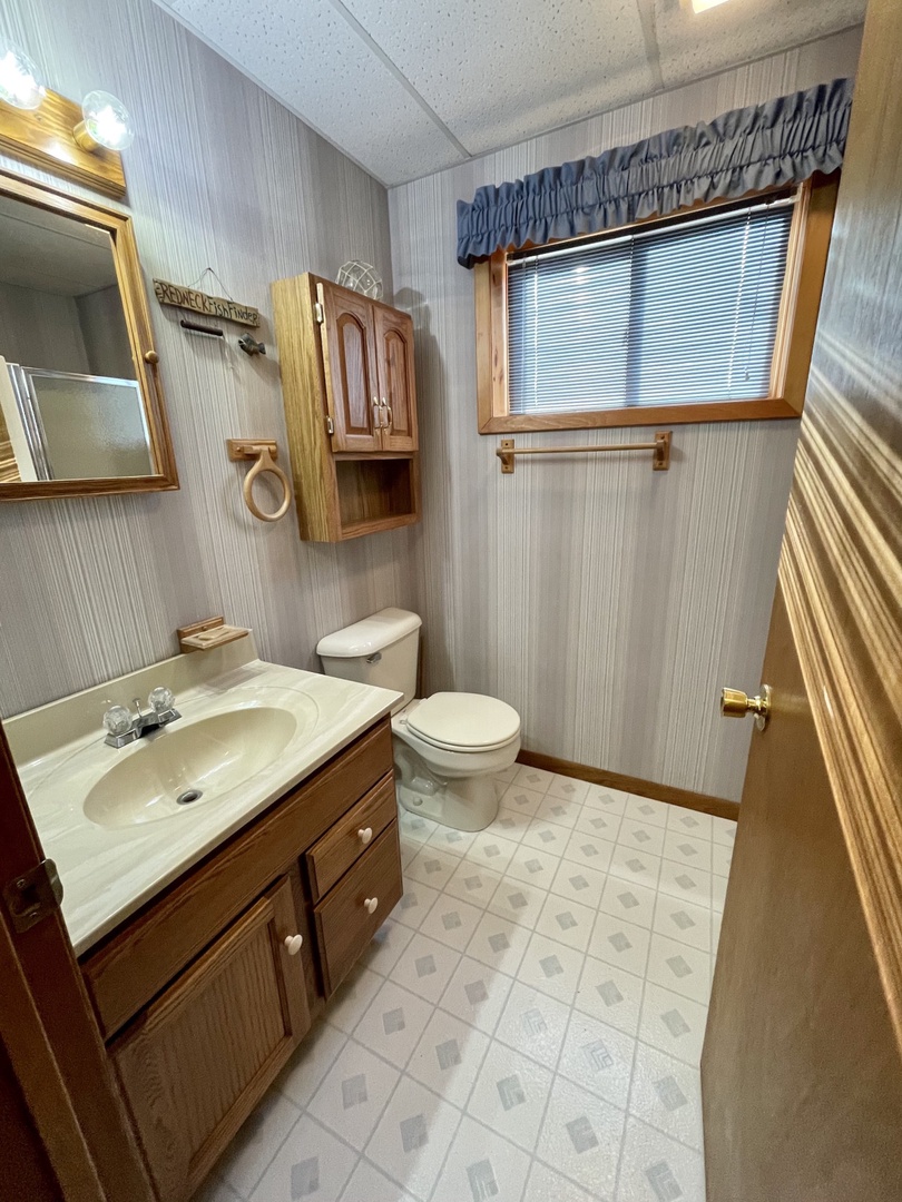Step into your private bathroom with classic wood cabinetry, spacious vanity, and charming country touches that make freshening up feel like home.