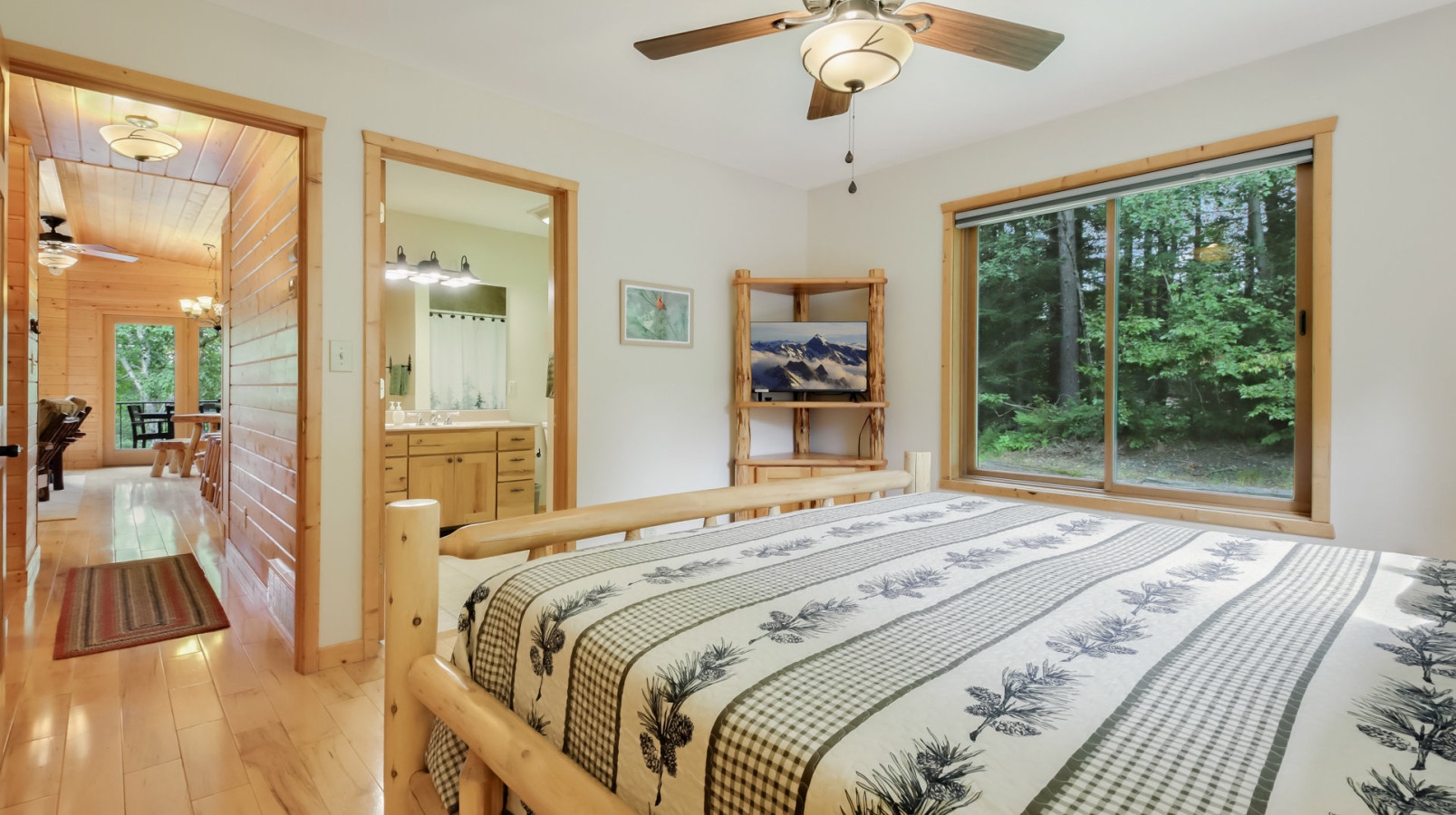 Relax in your serene bedroom with rustic charm, featuring a cozy log bed and peaceful forest views that invite restful sleep.
