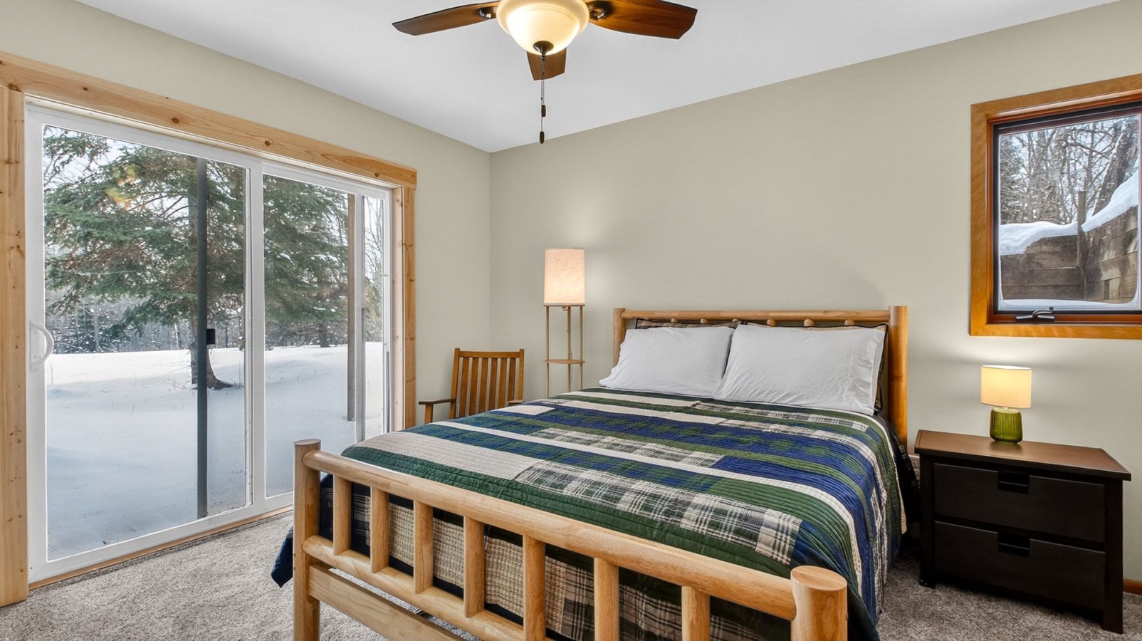Drift off to sleep in this cozy bedroom with warm wood accents and beautiful winter views from your private patio doors.