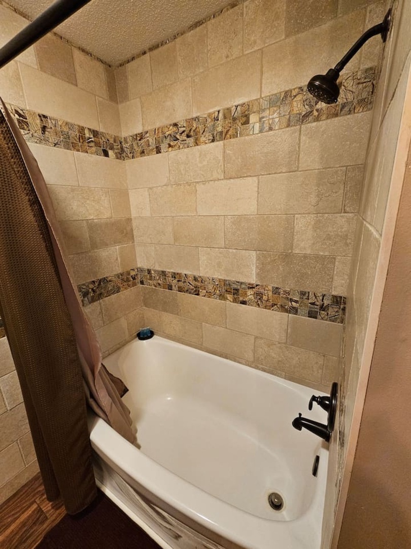 Unwind in your elegant tiled tub with decorative mosaic accents and convenient shower combo—perfect for relaxing after a day of exploring.