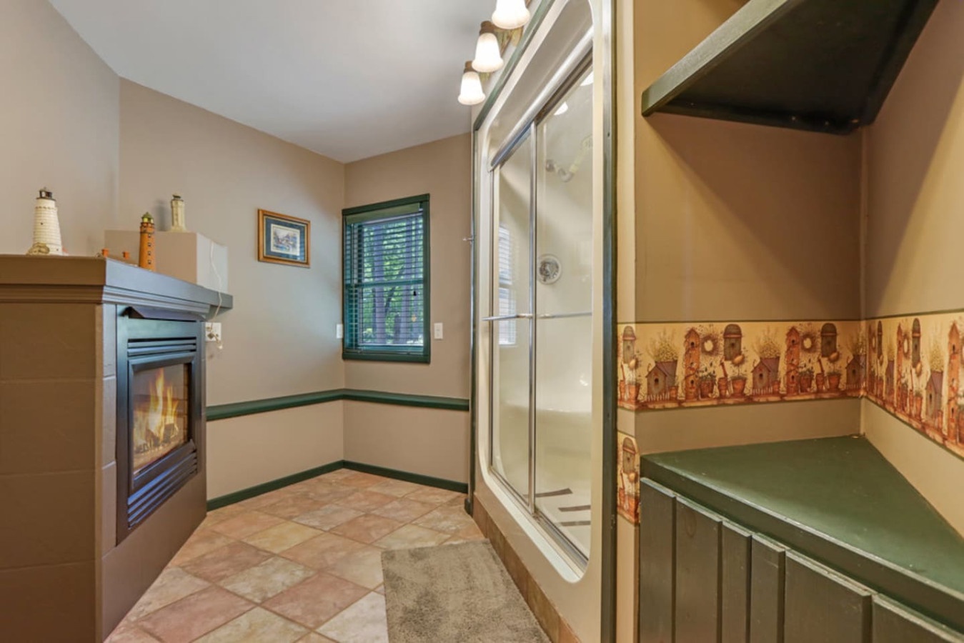 Unwind in your private spa-like bathroom with a cozy fireplace, glass shower, and soothing warmth for ultimate relaxation.