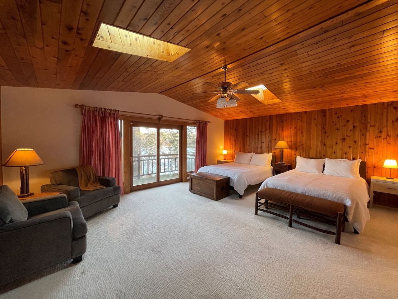 Unwind in this spacious bedroom featuring two comfortable beds, cozy seating, and warm wood accents that create your perfect mountain retreat.