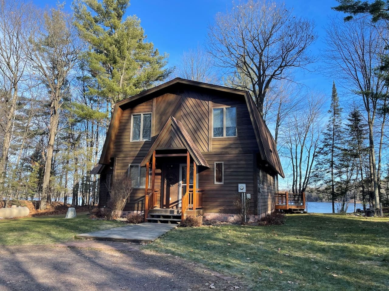 Charming lakefront cabin with rustic wood siding nestled among towering trees. The perfect retreat for peaceful mornings and scenic lake views.