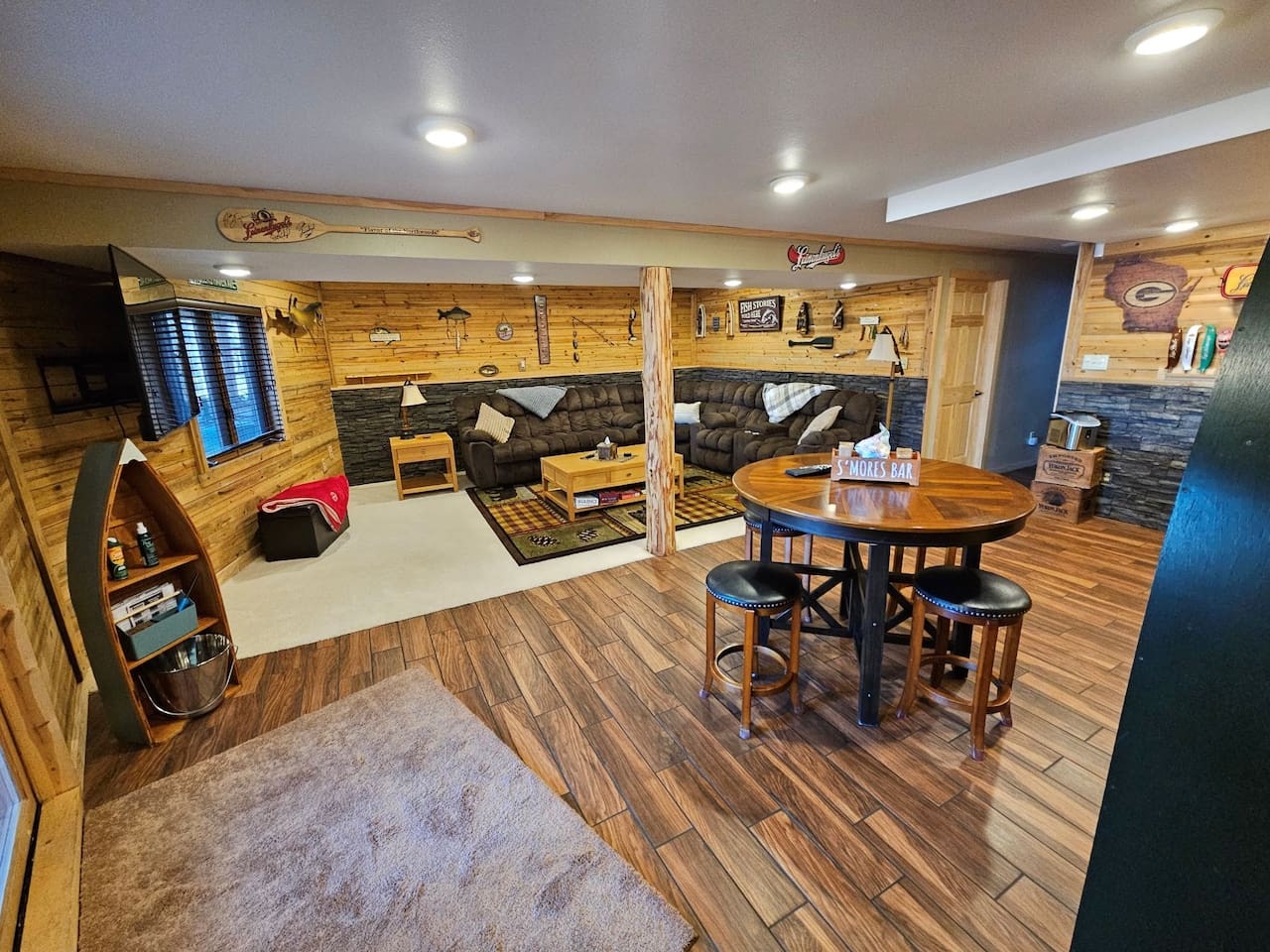 Your private game room features rustic wood paneling, cozy leather seating, and a perfect bar setup for memorable evenings.