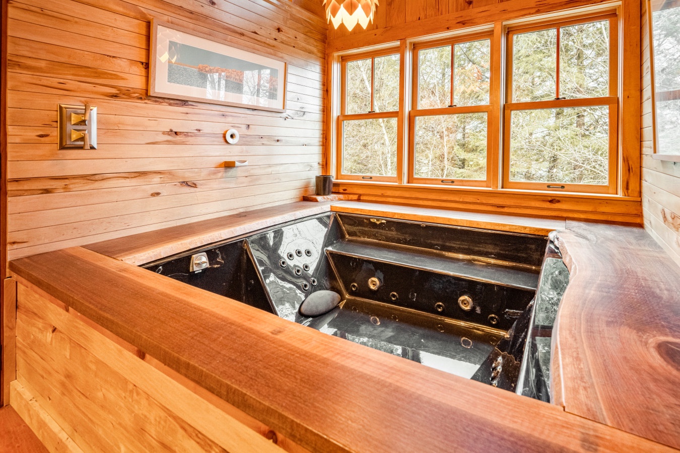 Soak your cares away in this luxurious sunken hot tub, surrounded by warm wood and forest views through panoramic windows.