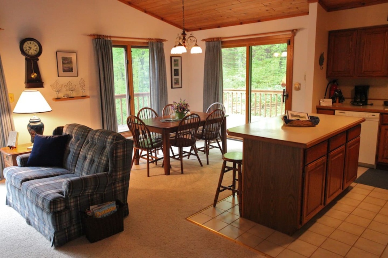 Relax in your cozy open-plan retreat with warm wood accents, comfortable seating, and peaceful forest views from your private balcony.