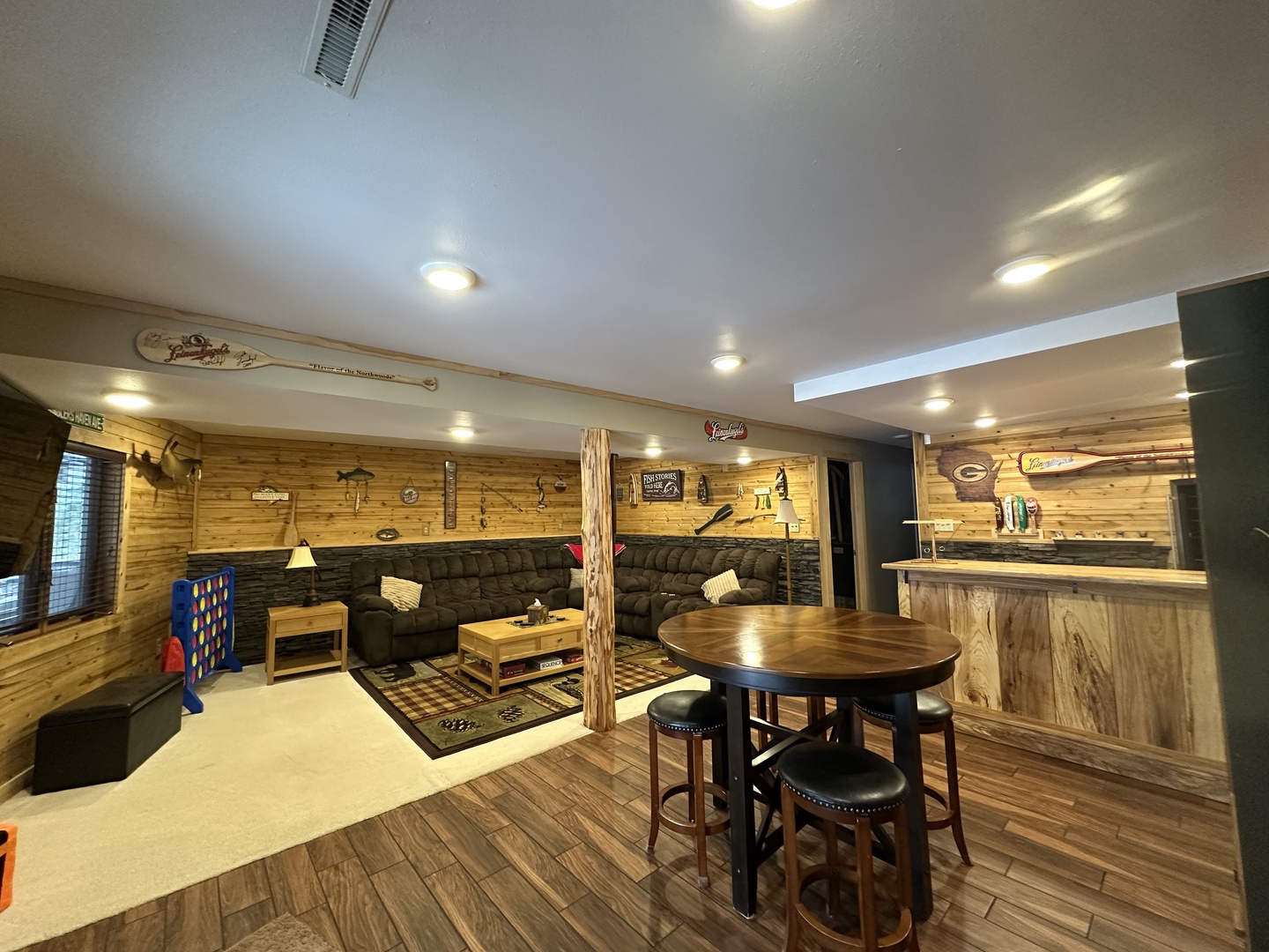 Your private basement retreat features rustic wood walls, comfy sectional seating, and a custom bar perfect for game nights and relaxing.