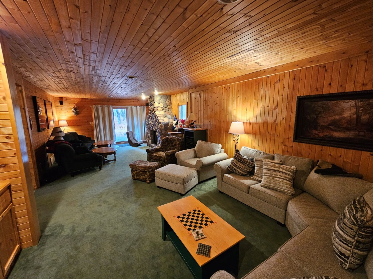 Sink into plush sofas surrounded by warm wood paneling, where your stone fireplace creates the perfect cozy atmosphere for movie nights.