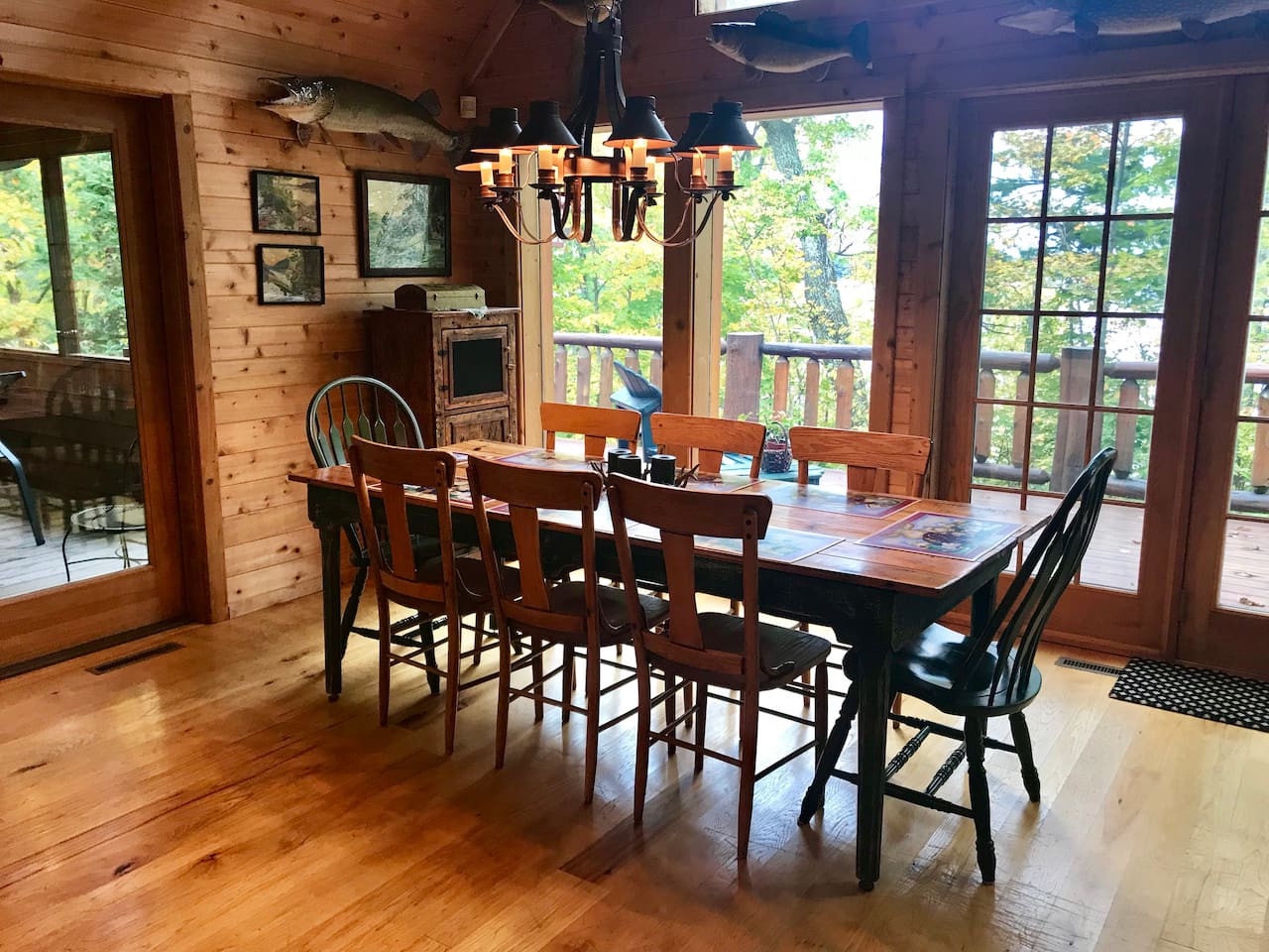 Gather around the rustic dining table where meals become memories, surrounded by warm wood and peaceful forest views through expansive windows.