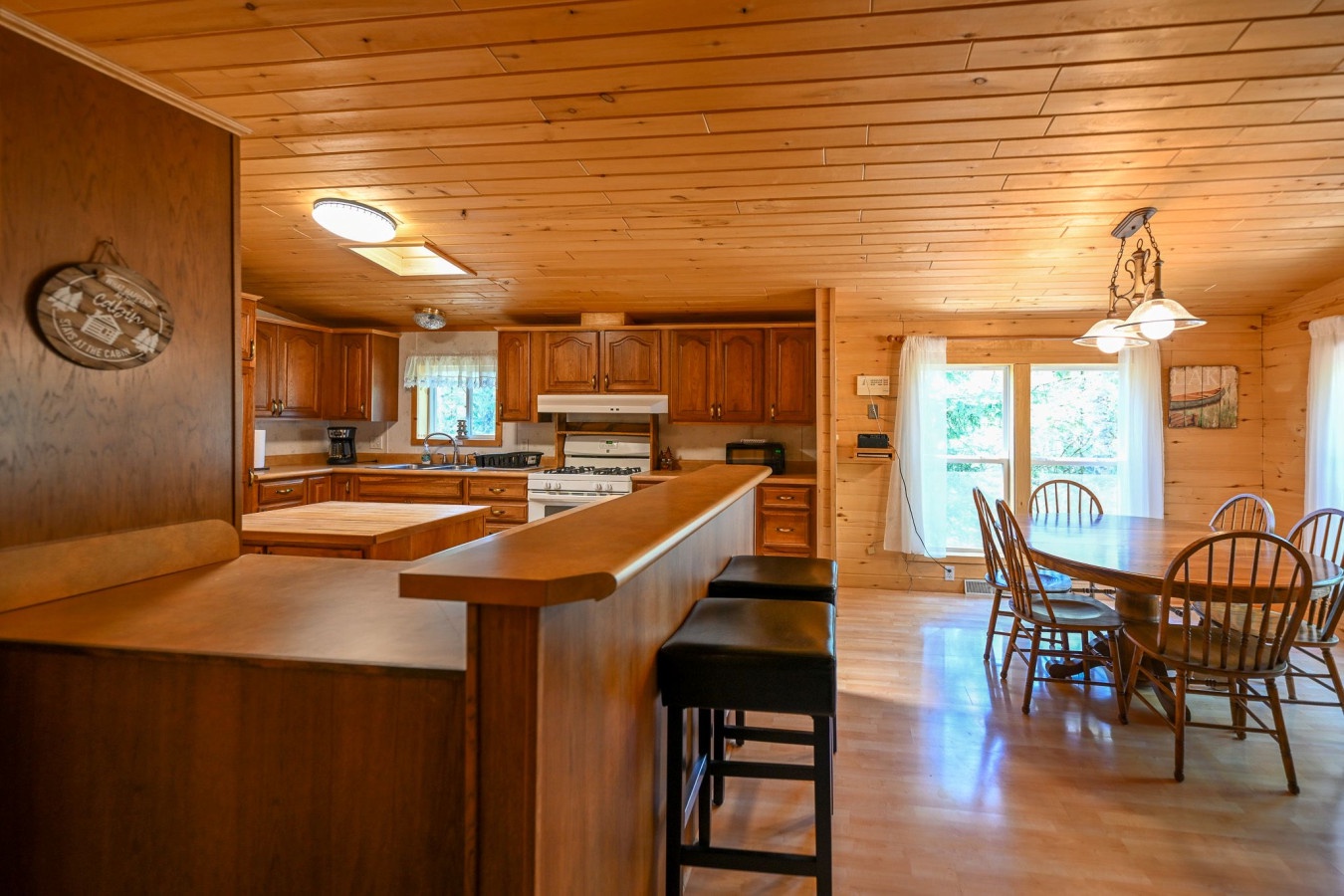 Your spacious cabin kitchen invites family gatherings with warm wood finishes, full appliances, and a breakfast bar perfect for morning coffee.