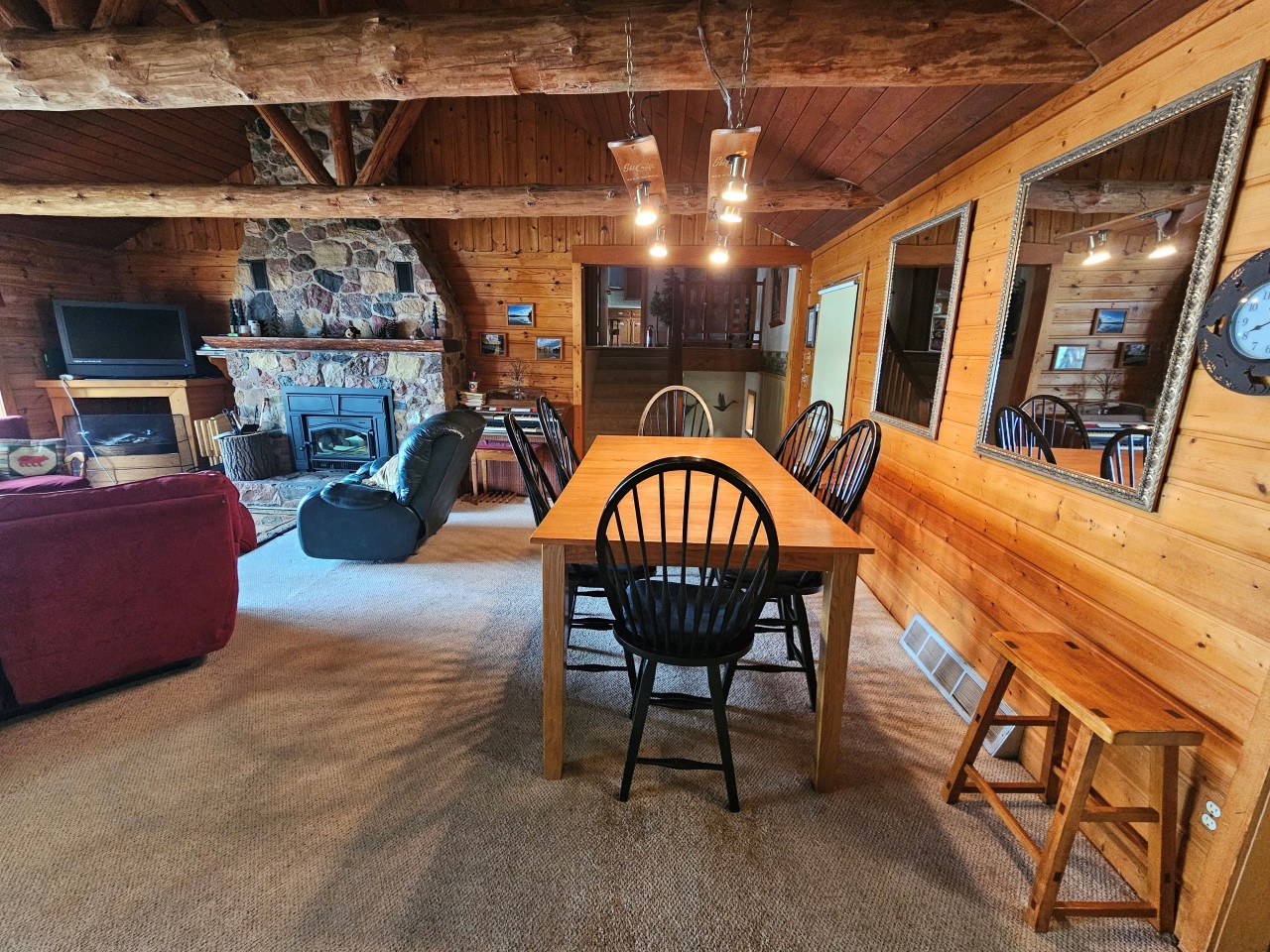 Gather around the handcrafted dining table in this cozy cabin, where exposed beams and stone fireplace create the perfect atmosphere for memorable meals together.