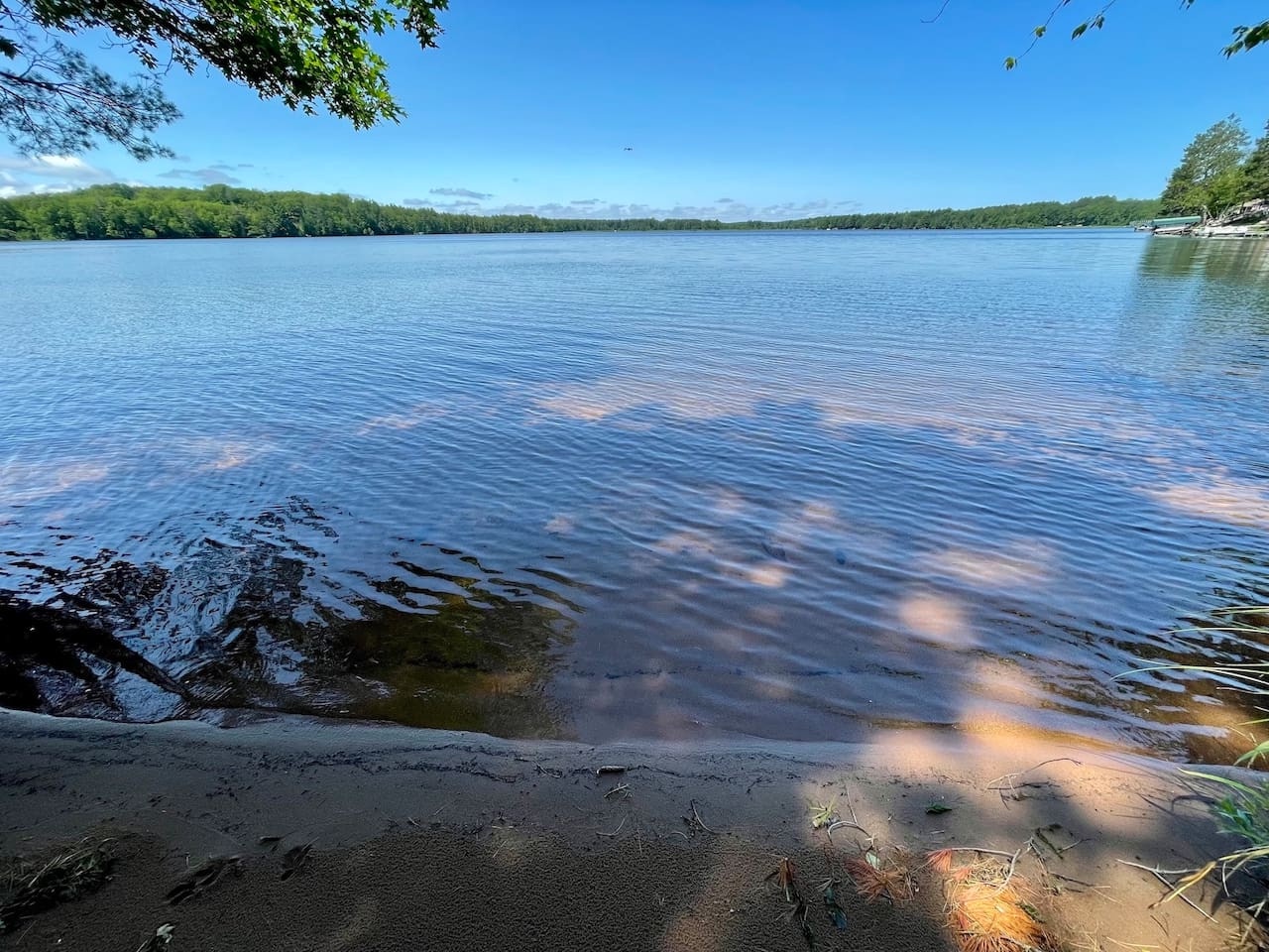 A pristine lake surrounded by lush forest creates a peaceful natural setting for the property.