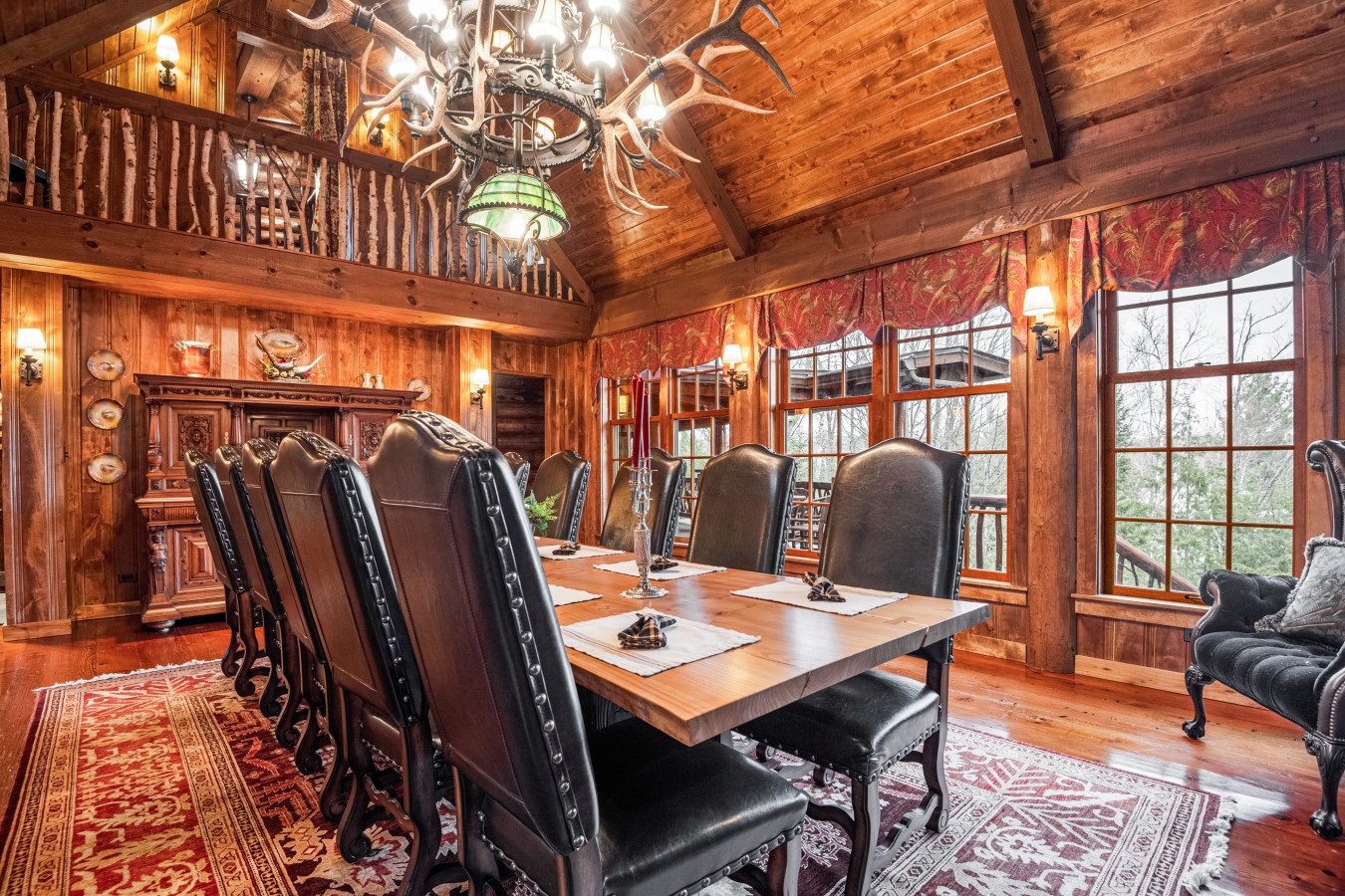 Gather around this grand dining table beneath the striking antler chandelier, where rustic elegance meets mountain charm in your perfect retreat.