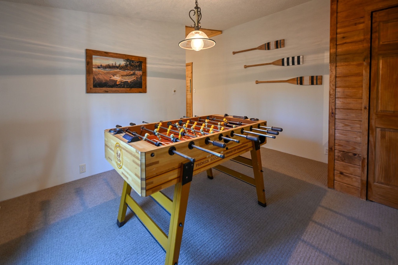 Challenge your friends to exciting foosball matches in this cozy game room, complete with authentic wooden paddles and rustic charm.