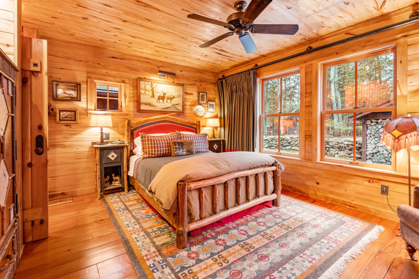 Drift off in this cozy rustic bedroom where warm wood walls and soft quilted bedding create your perfect mountain retreat.