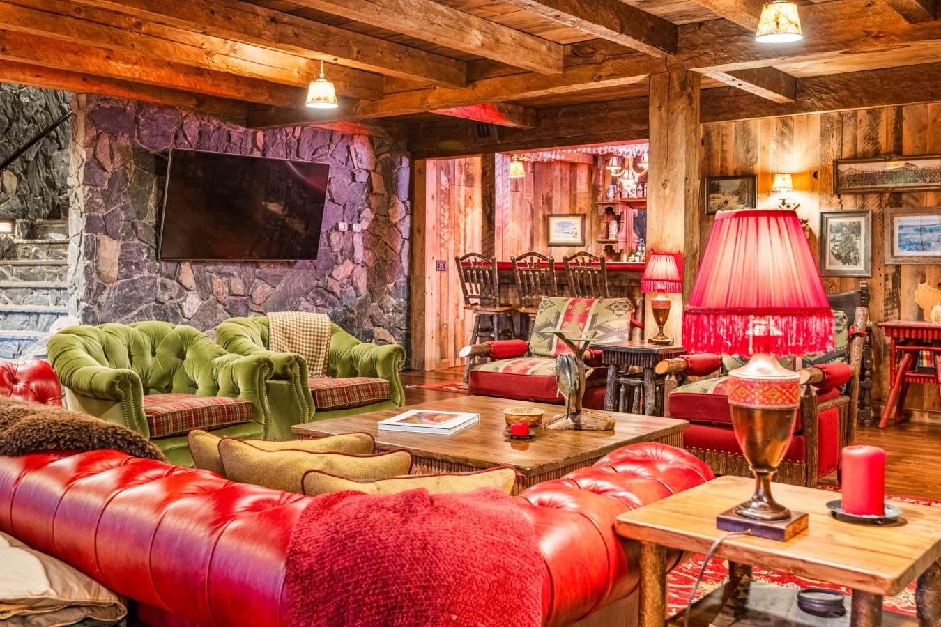 Sink into plush leather seating surrounded by warm wood beams and stone accents. Your cozy retreat awaits with rustic charm and modern comfort.