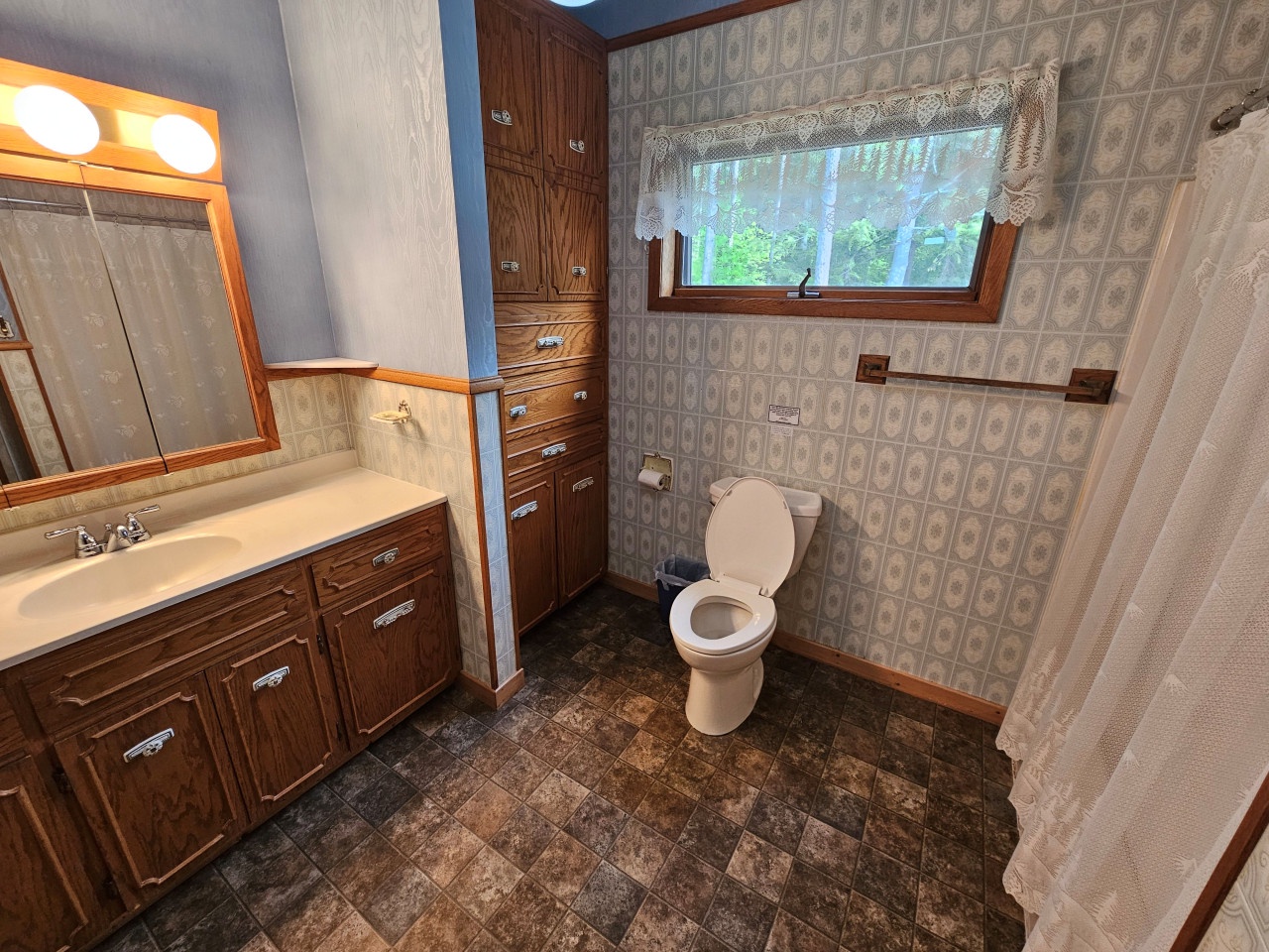 Your private bathroom features abundant storage, warm lighting, and a peaceful garden view for a relaxing retreat.