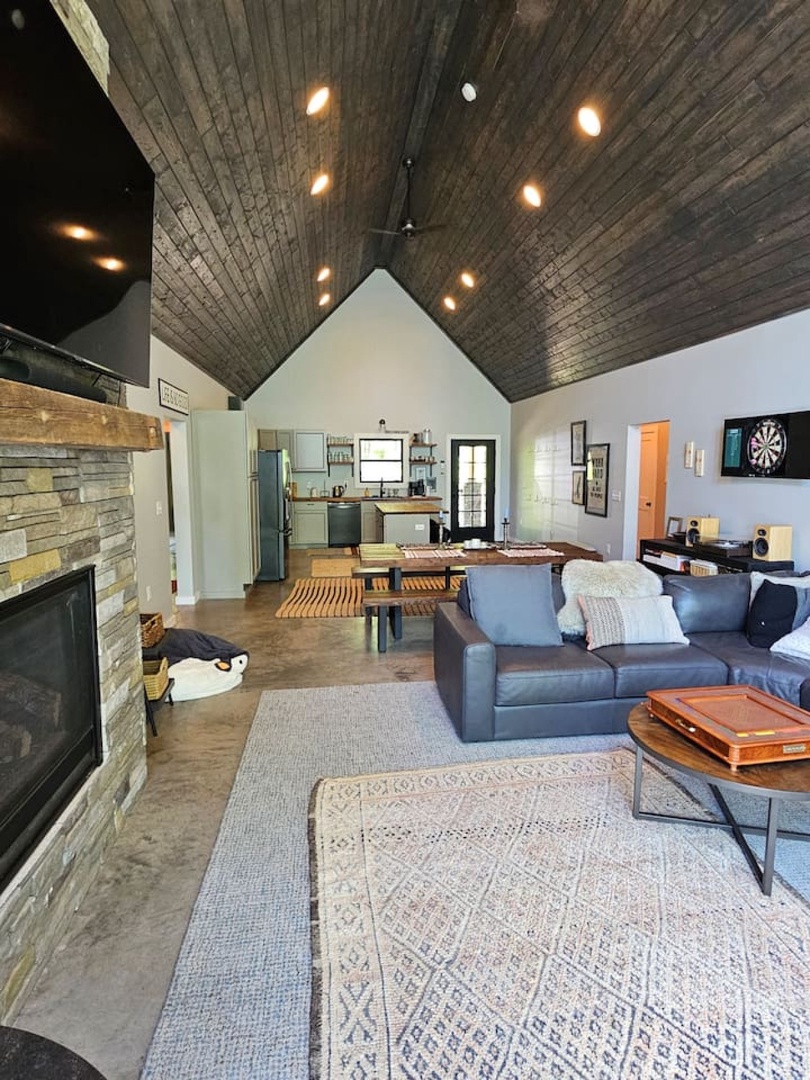 Unwind in your stylish open-plan retreat with soaring wood ceilings, cozy fireplace, and entertainment ready for memorable evenings.