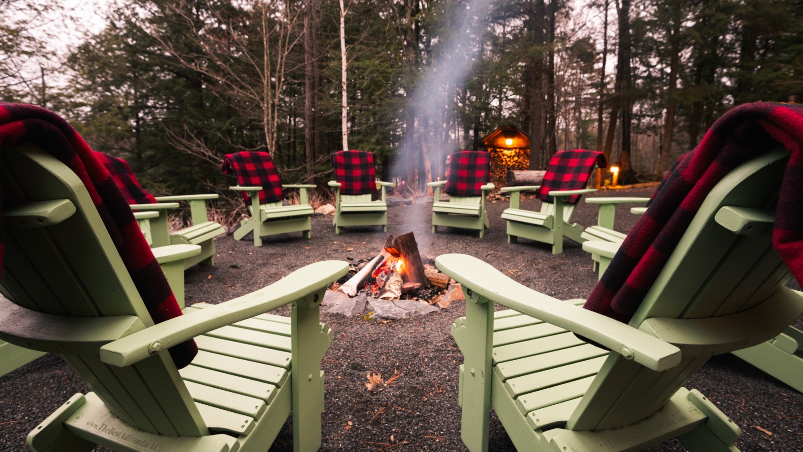 Gather around the crackling fire pit where cozy Adirondack chairs with buffalo plaid blankets invite you to share stories under the stars.