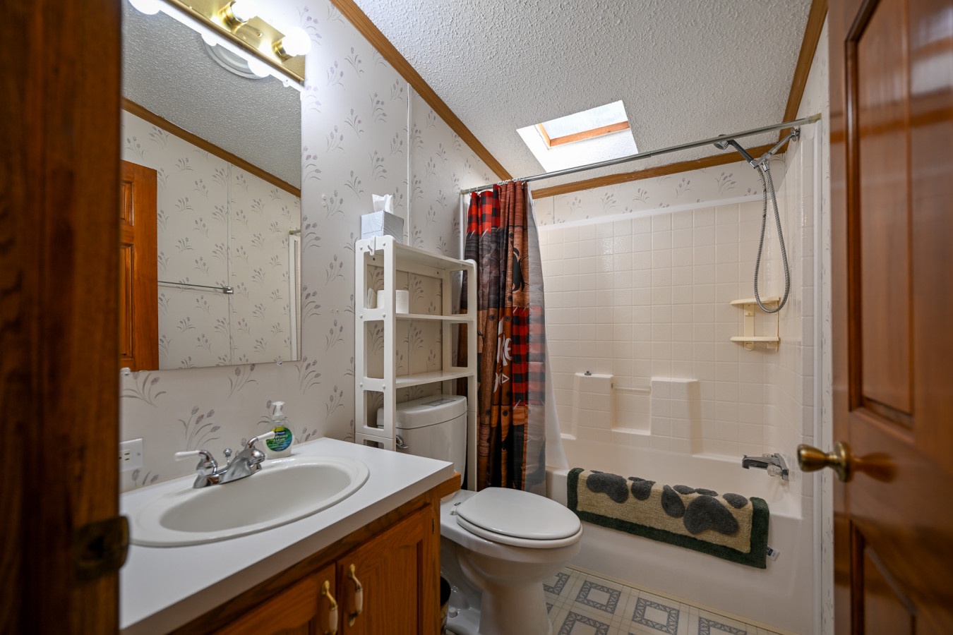 Your private bathroom features a full bathtub-shower combo with charming woodland wallpaper and all the essentials for a comfortable stay.