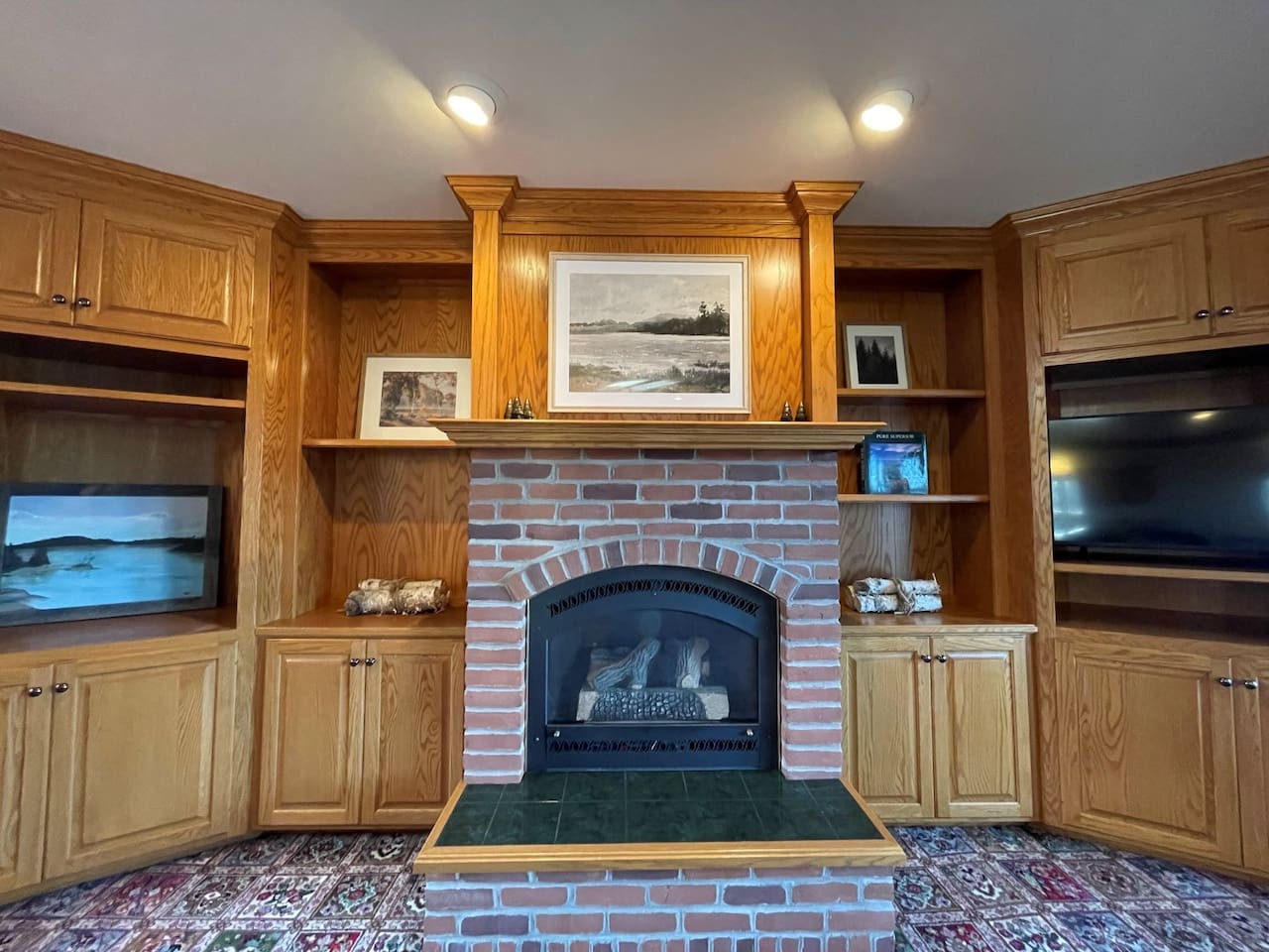Cozy up by your beautiful brick fireplace, surrounded by warm wood cabinetry and built-in entertainment center for perfect relaxation.