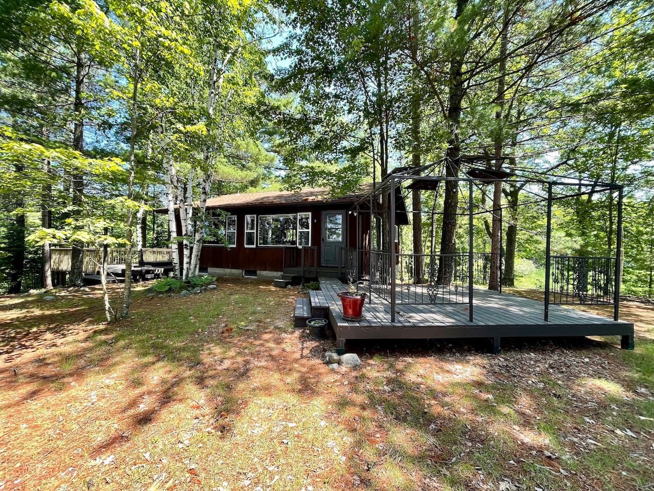 A charming woodland cabin surrounded by towering trees offers peaceful forest living with a spacious deck perfect for morning coffee and outdoor relaxation.